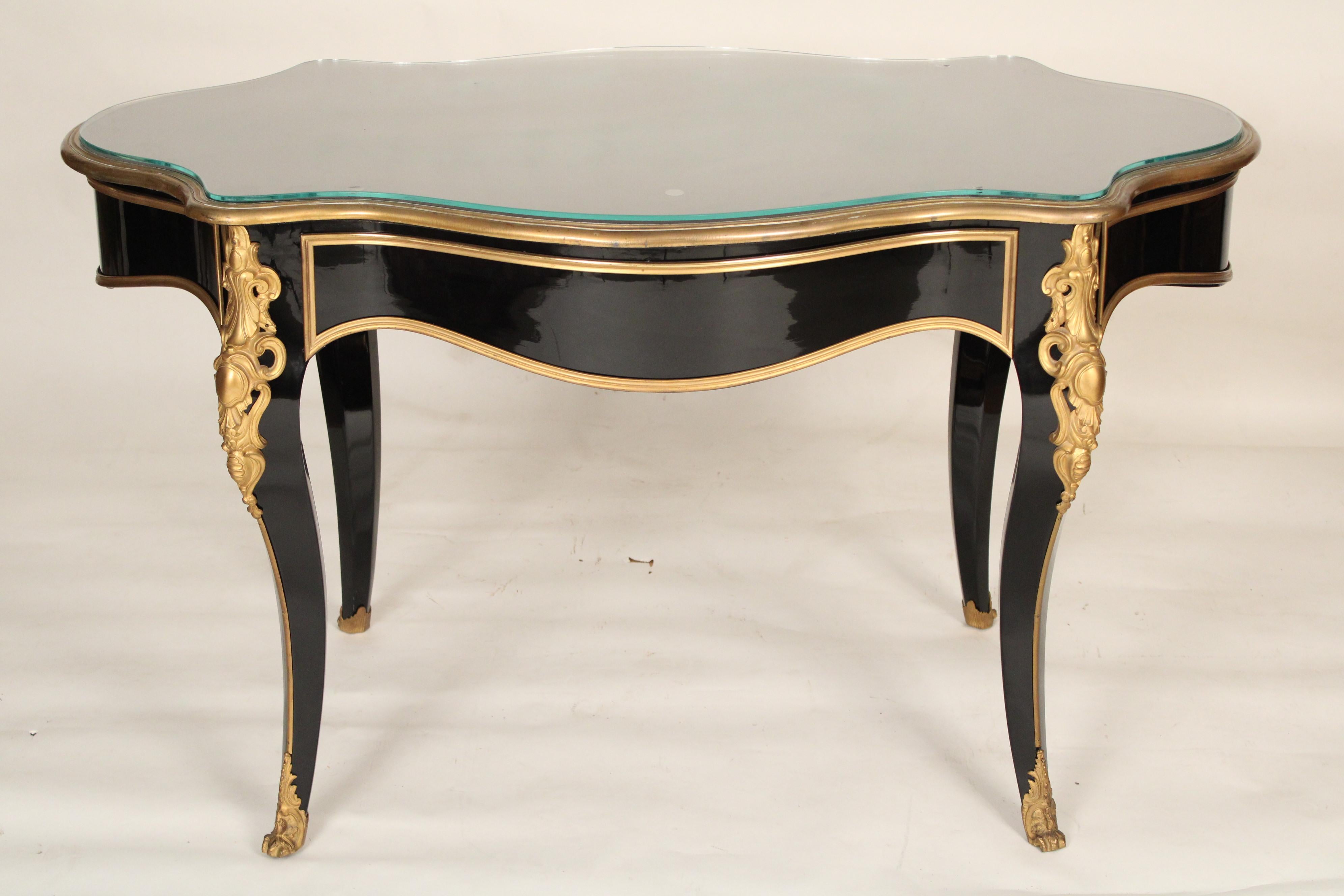Napoleon III black lacquer and gilt bronze mounted writing / center table with a glass top, late 19th century. Excellent quality late 20th century black lacquer finish. Lemon colored gilt bronze mounts. Back of drawers with hand dove tailed drawer