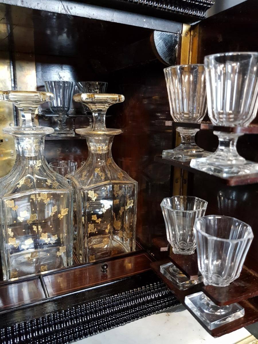 Rare cave à liqueur and Cigar Cabineton Boulle marquetry style with three noble materials and a stunning full set of Baccarat crystal including
Three crystal carafe bottles and
16 crystal glasses
Rare model where four parts can be open and the