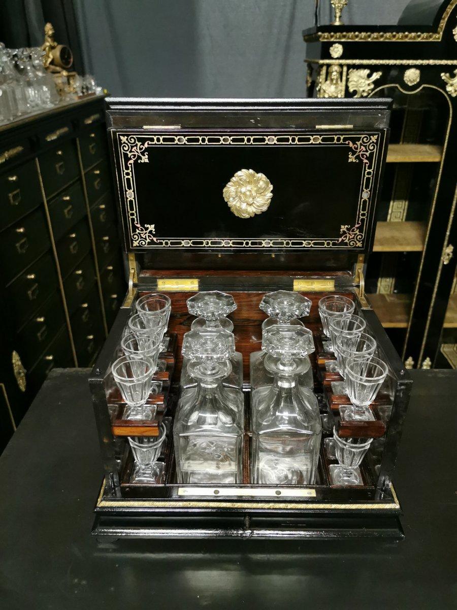 Napoleon III liquor cellar cabinet in Boulle style marquetry in brass and copper ball, with scrolls and interlacing patterns.
Ornamental bronzes with rosettes, handles, ingot mold.
Baccarat crystal glassware set with 4 decanters and 16 glasses.