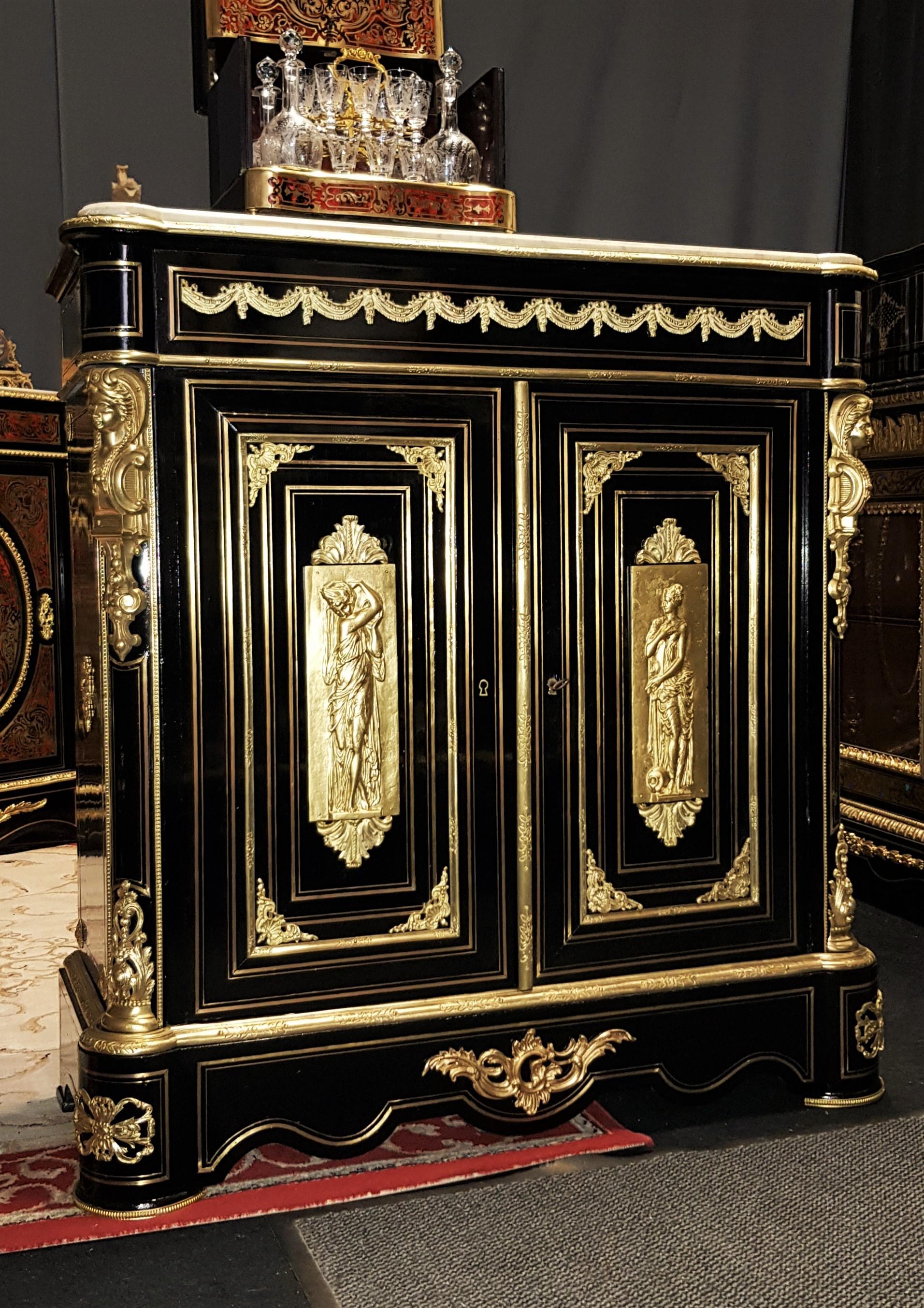 Rare cabinet in blackened pear tree wood and Boulle Marquetry with brass ornamentations. With important and rich gilt bronze ornamentations.
On the doors made in an ancient style decoration, 2 plaques in bronze representing the vestal virgins, the