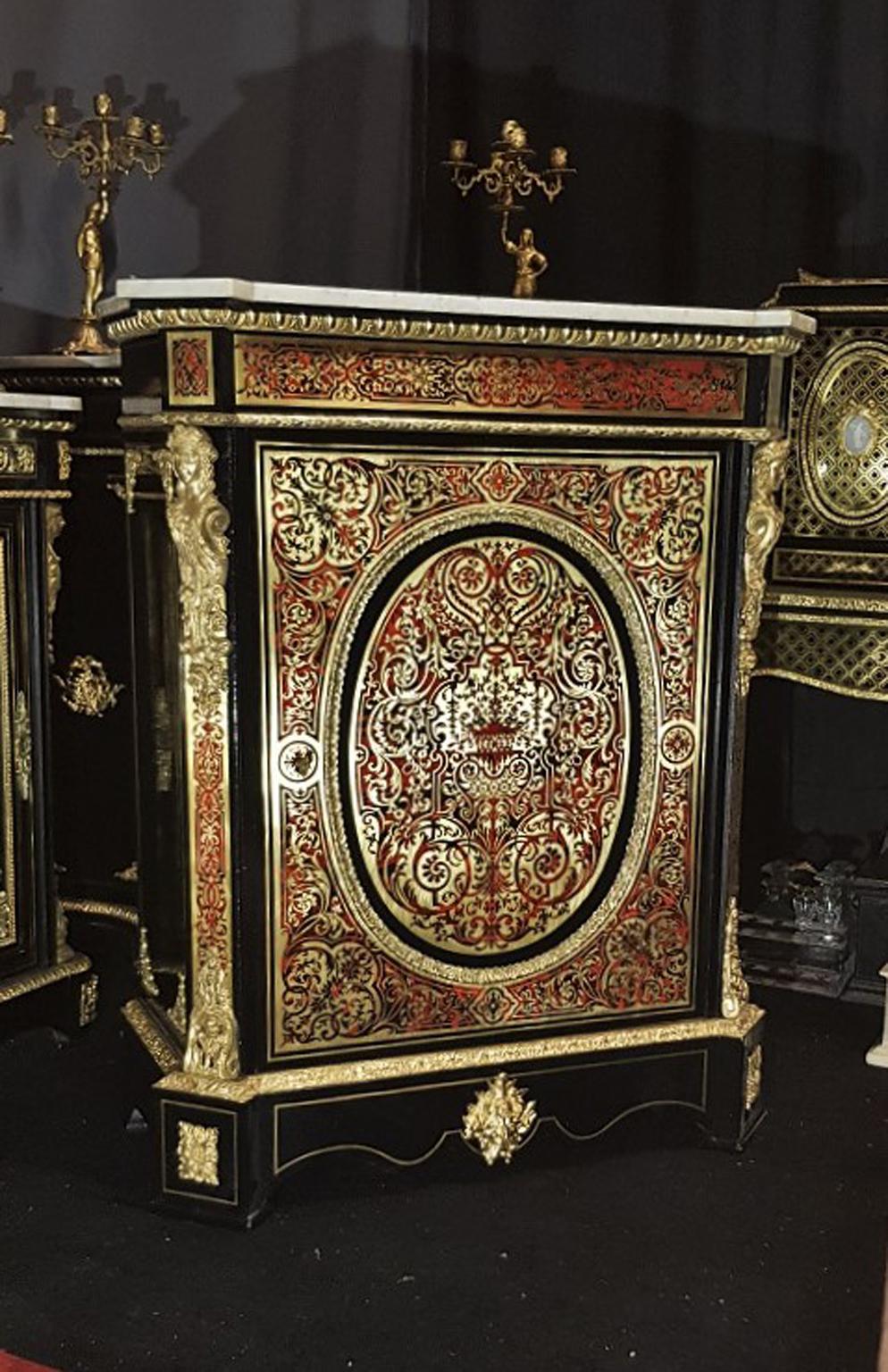 Gorgeous Boulle Marquetry Cabinet in red  Horn and Brass with rich ornementations. à riche décor d’entrelacs, volutes, rinceaux, urnes et bouquets. Gorgeous Gilt Bronze decoration details and 2 big Caryathids and a Faun mask .
White Carrara marble