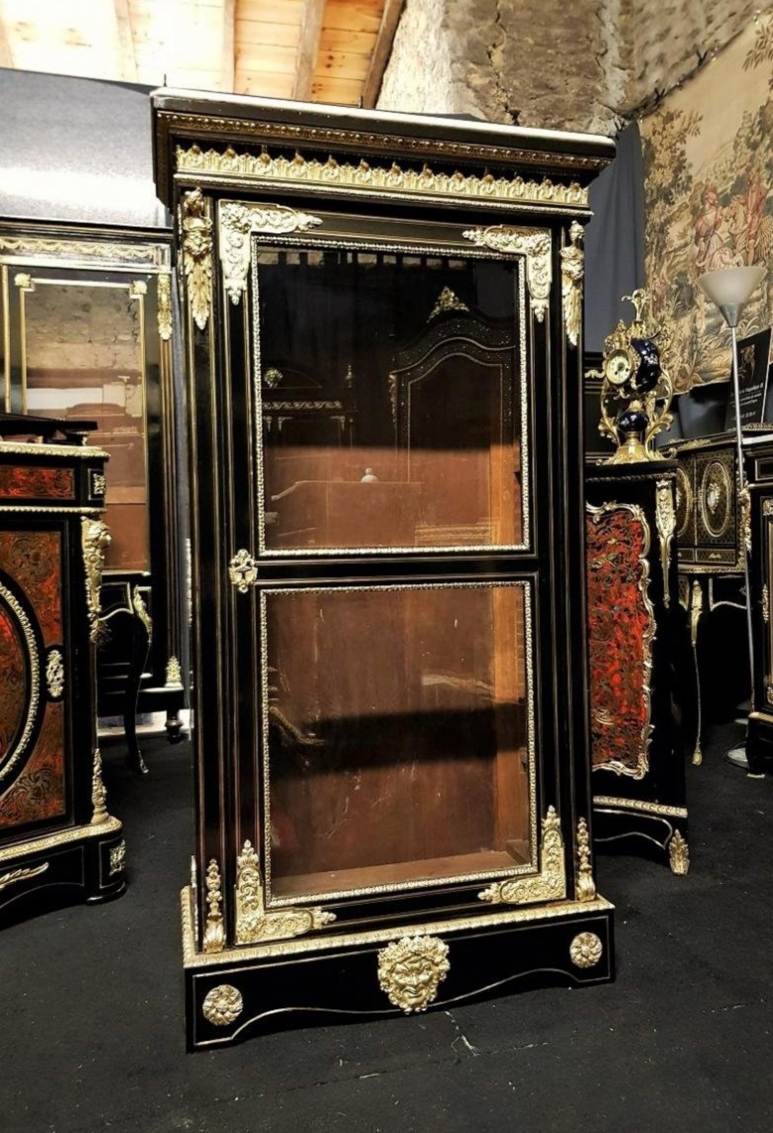 Rare bookcase Vitrine in Boulle style marquetry in brass nets with one door 1 door in marquetry with brass nets and gorgeous ornamentation of gilded bronzes with Bacchus mask, spandrels, multiple ingot molds, gallery in acanthus leaves on the upper