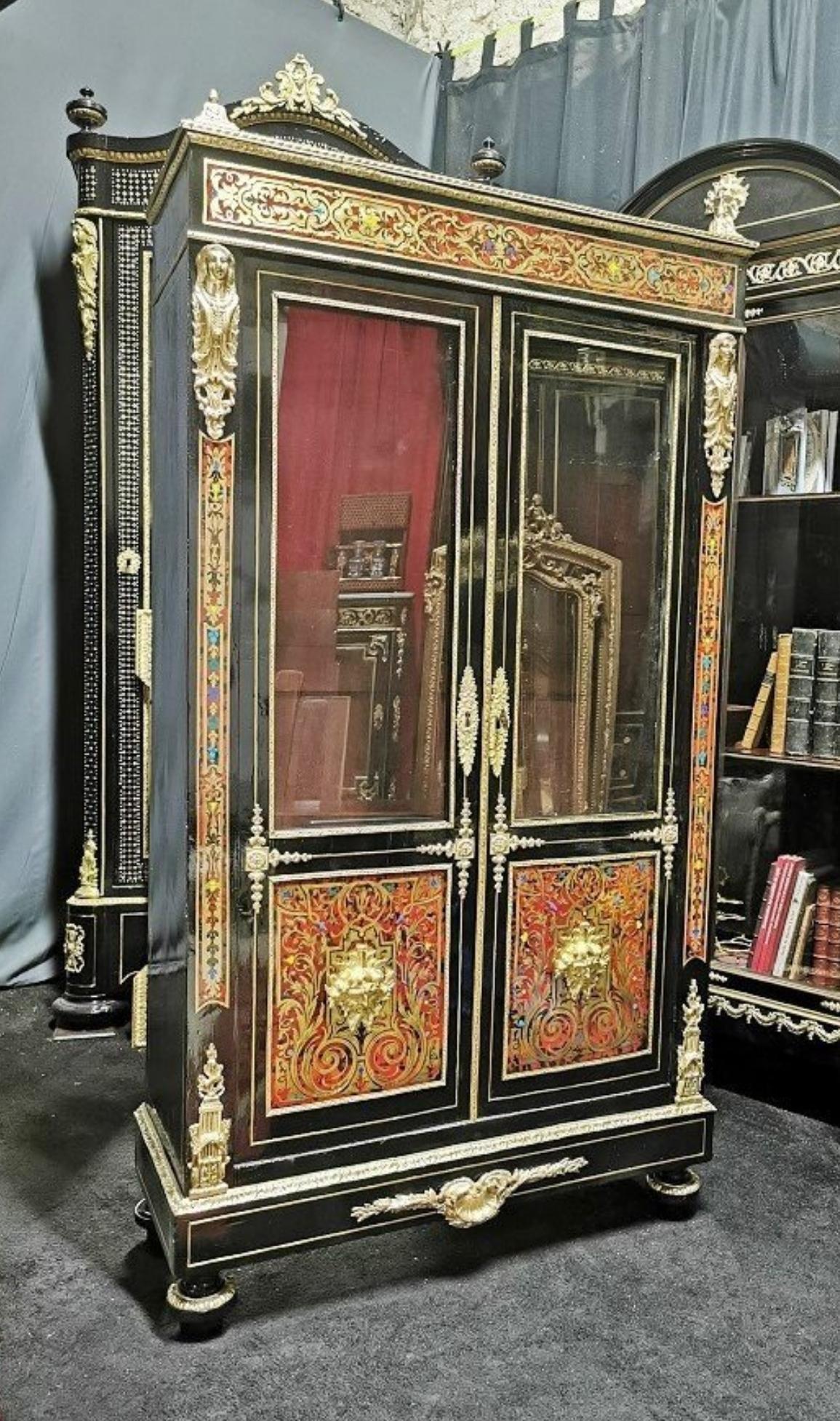 Napoleon III bookcase vitrine with two doors in Boulle Marquetry style in brass ball marquetry and tortoiseshell, with interlacing patterns and scrolls. Beautiful ornamentation of gilded bronzes with molds, masques and falls.
Restored by our