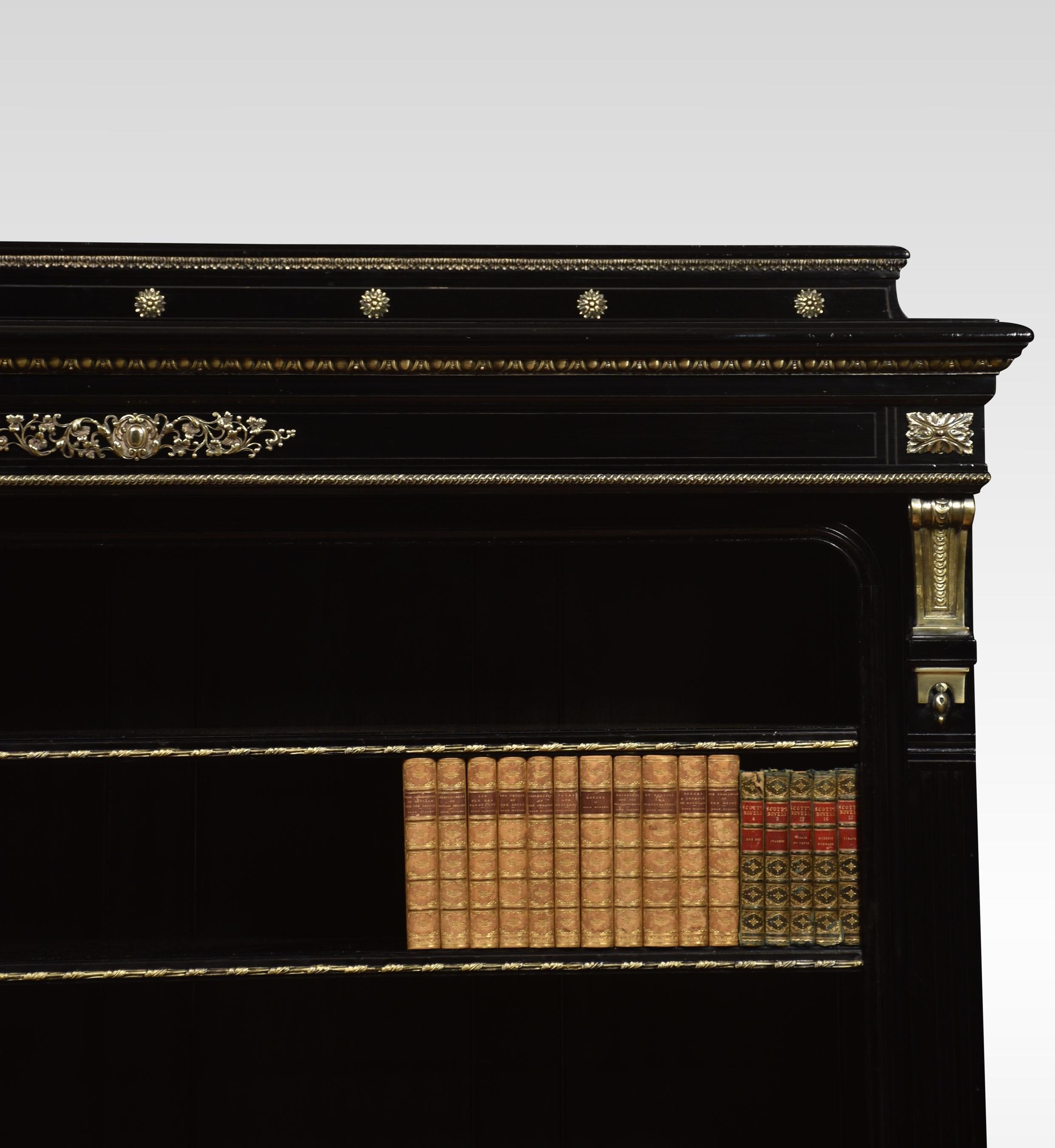 19th Century ebonised and gilt mounted open bookcase having foliage gilt decoration throughout. The quarter gallery top with moulded edge, over an ornate gilt egg and floral scrolling design mounted on the frieze. Above three adjustable shelves,