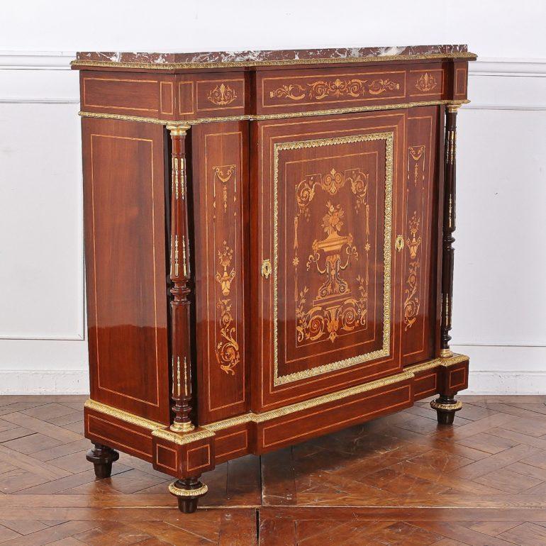 A fabulous quality, highly-inlaid, French marble-top breakfront side cabinet, the door and side panels lavishly inlaid with swags, urns, scrolls, flowers, etc. Classical fluted tapering columns accent the front corners, the case is further accented