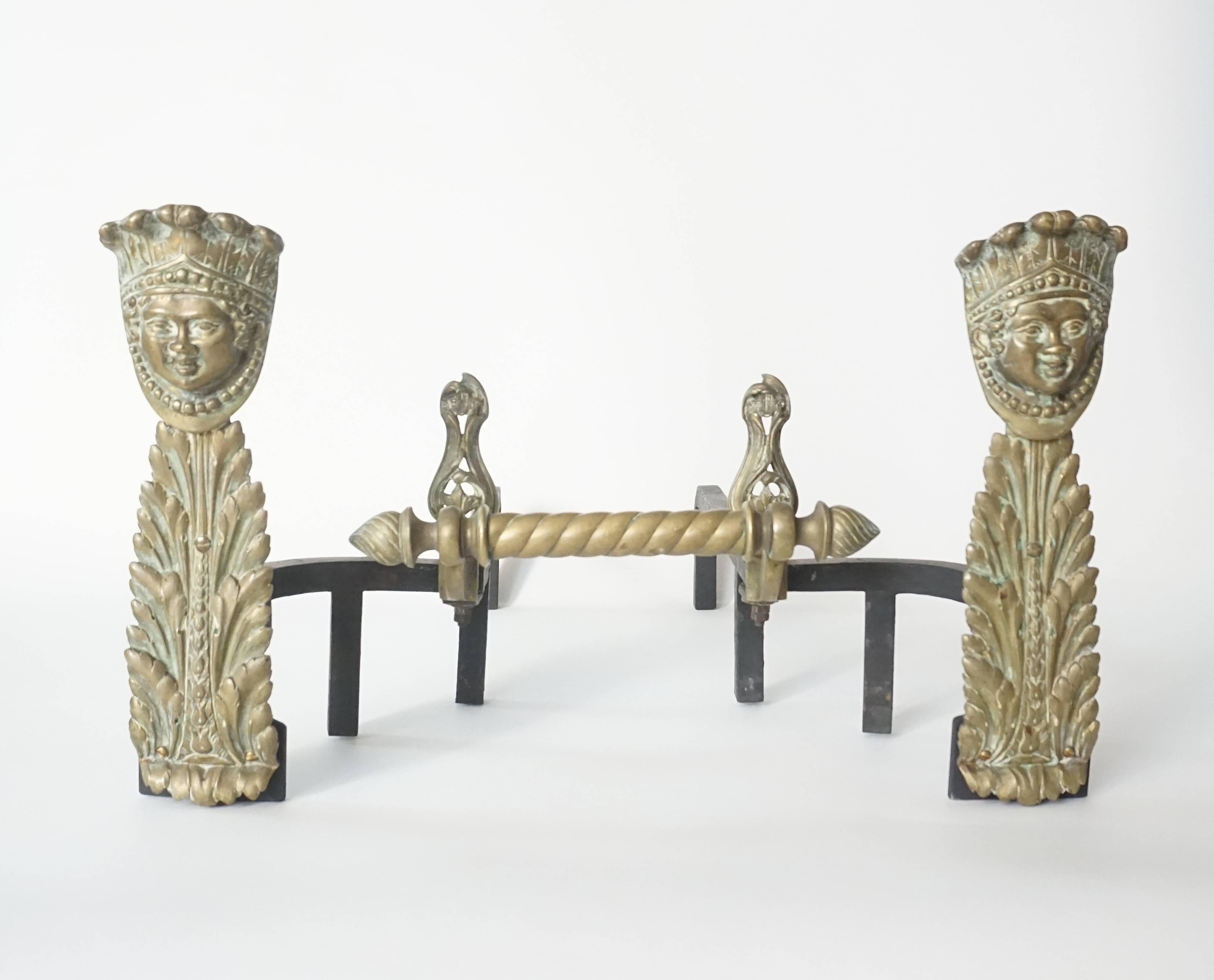 Unusual pair of French Napoleon III period firebox andirons having cast bronze 'Indian Head in Feather Headdress' form finials on foliate acanthus chenet front standards connecting iron log holders joined by bronze spiral bar with spiral end finials