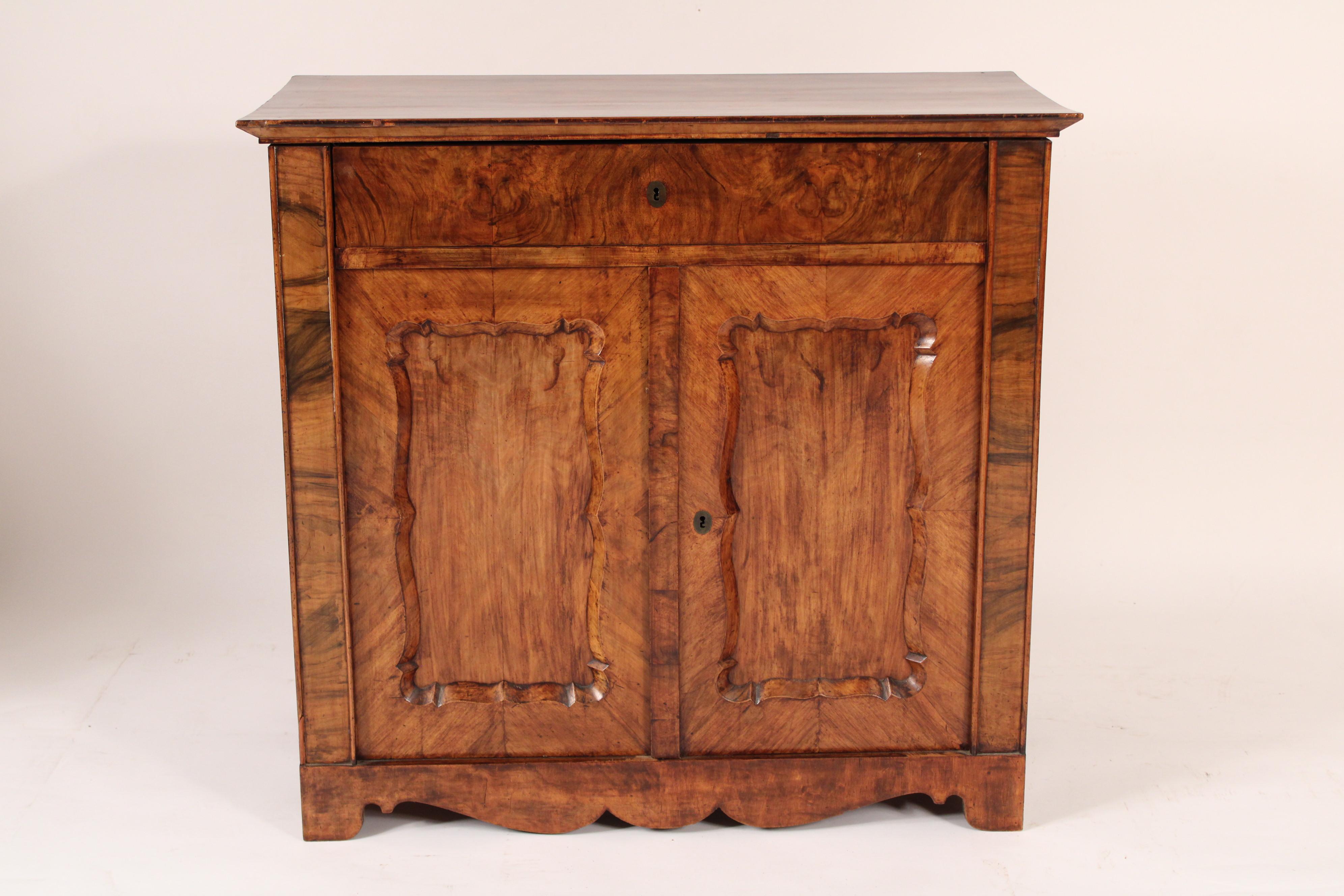 Napoleon III burl walnut, birch and grain painted cabinet, circa 1860. With a burl walnut over hanging top, a burl walnut drawer, two doors with walnut chamfred scalloped frames inset with grain painted birch panels, grain painted sides and