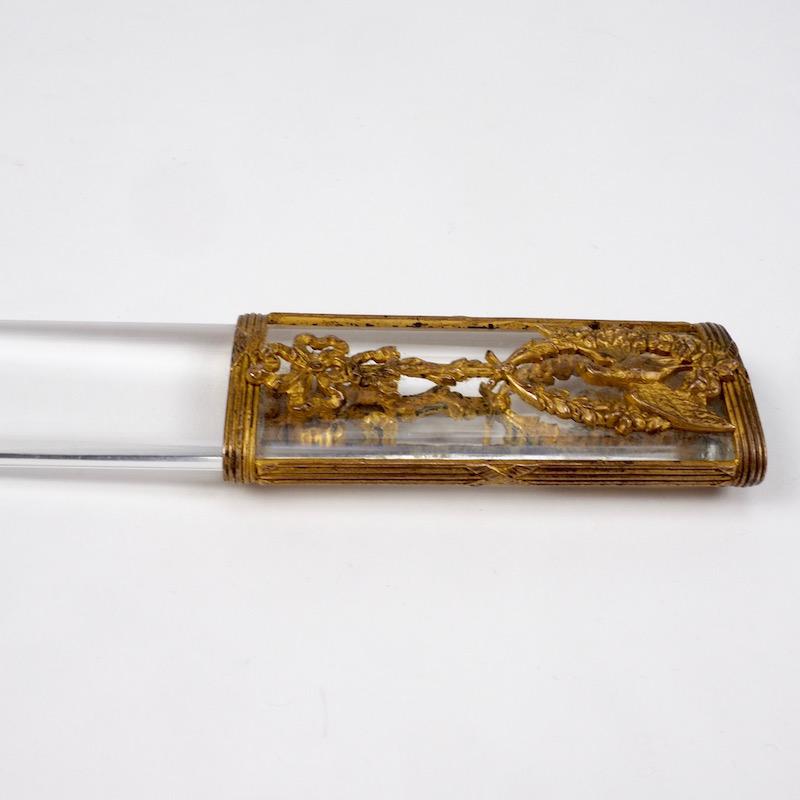Napoleon III rock crystal and gilt page turner in the Louis IX style popular at the time. This elegantly balanced piece of solid crystal accented with gilt swags and birds would compliment any library or escritoire. Page turners like these were also