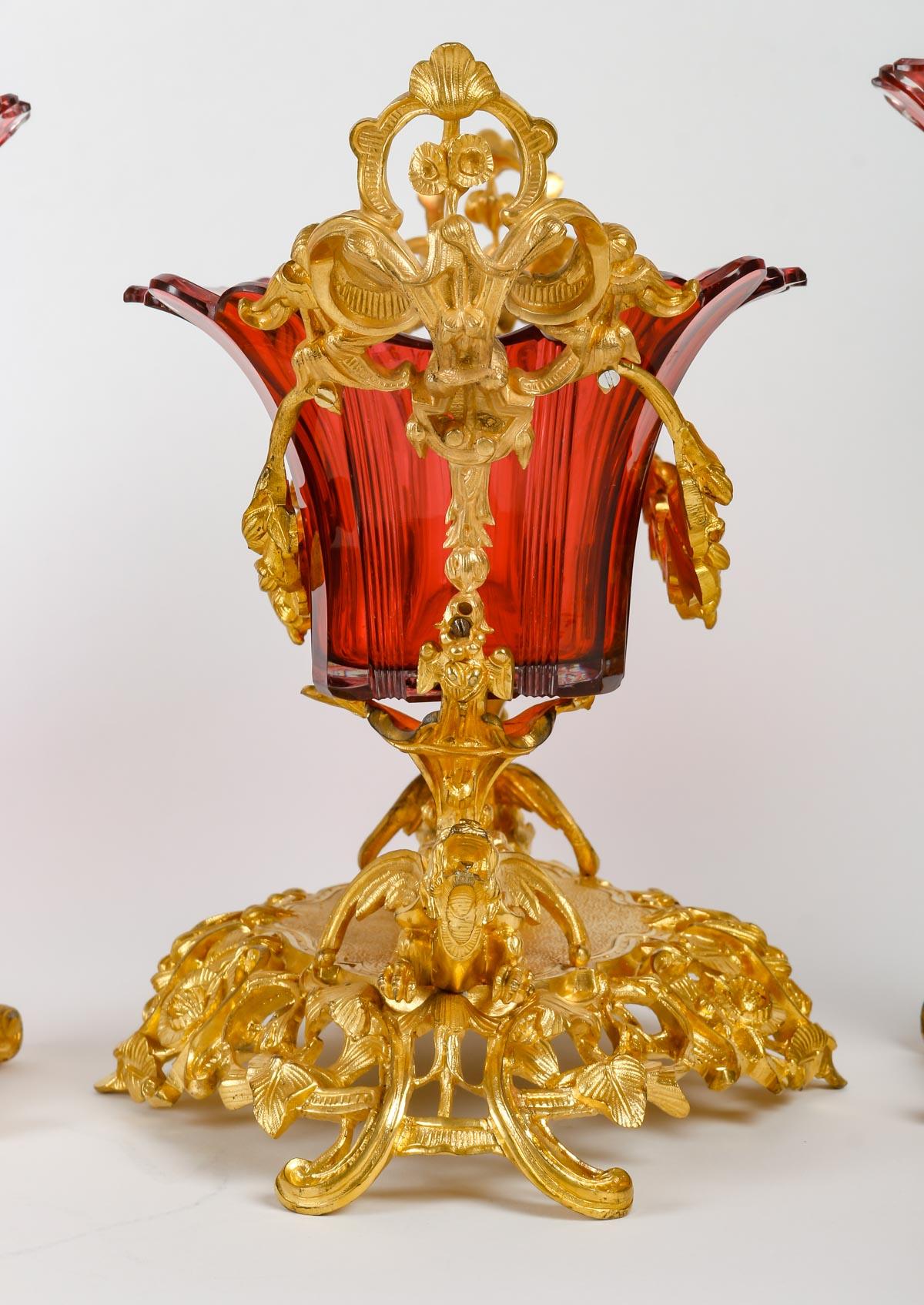 Napoleon III crystal set consisting of a bowl and two cornet vases.

Red cut Bohemian crystal set, gilded bronze frame composed of a bowl and two cornet vases, 19th century, Napoleon III period.

dimensions : 
Bowl: h: 29cm, w: 37cm, d: 23cm
Cornet: