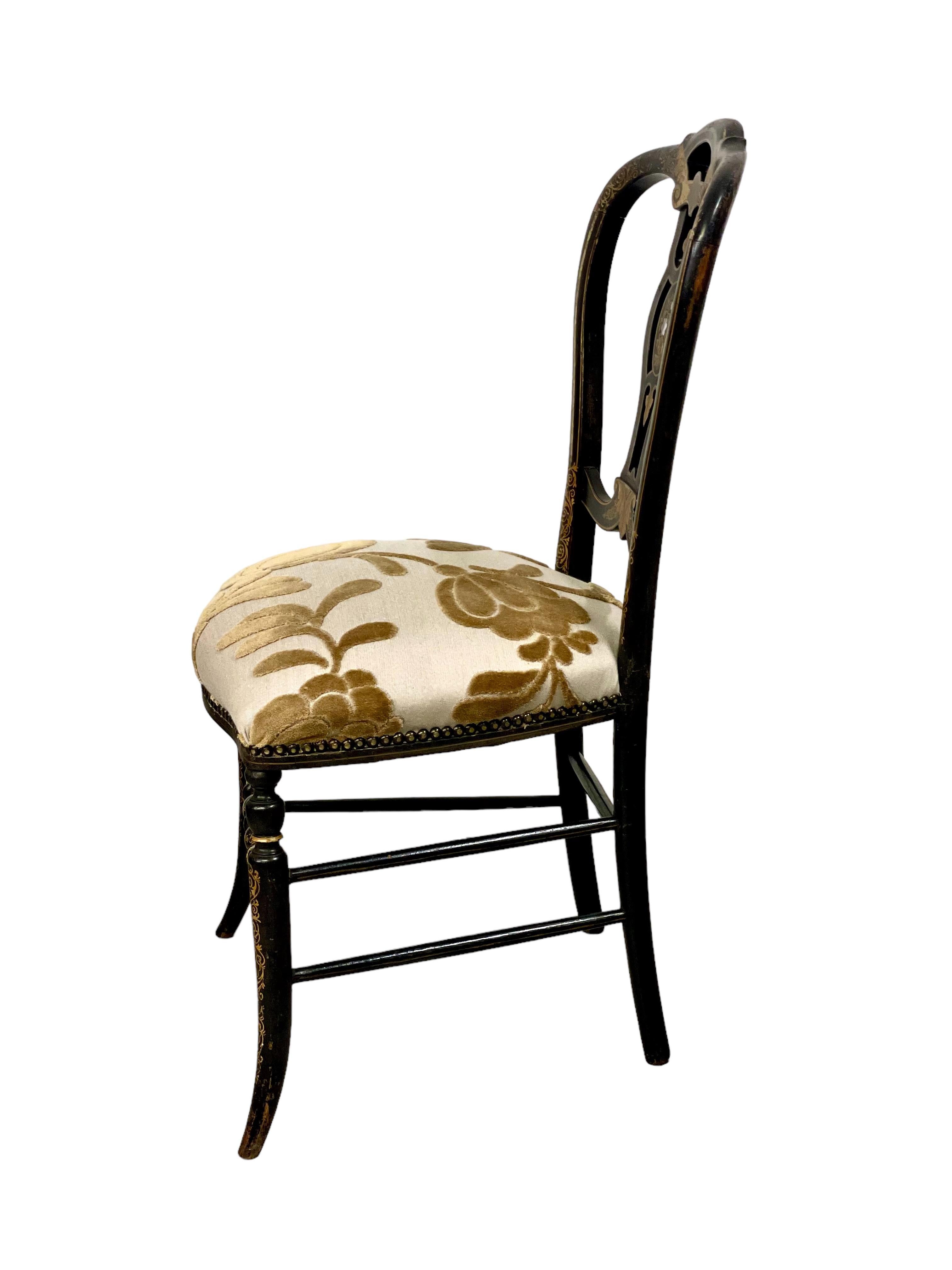Élégante chaise chauffeuse décorative du XIXe siècle, d'époque Napoléon III, dont le profond et confortable coussin d'assise est magnifiquement tapissé d'un remarquable tissu crème et bronze, fixé sur tout le pourtour par une garniture de têtes de
