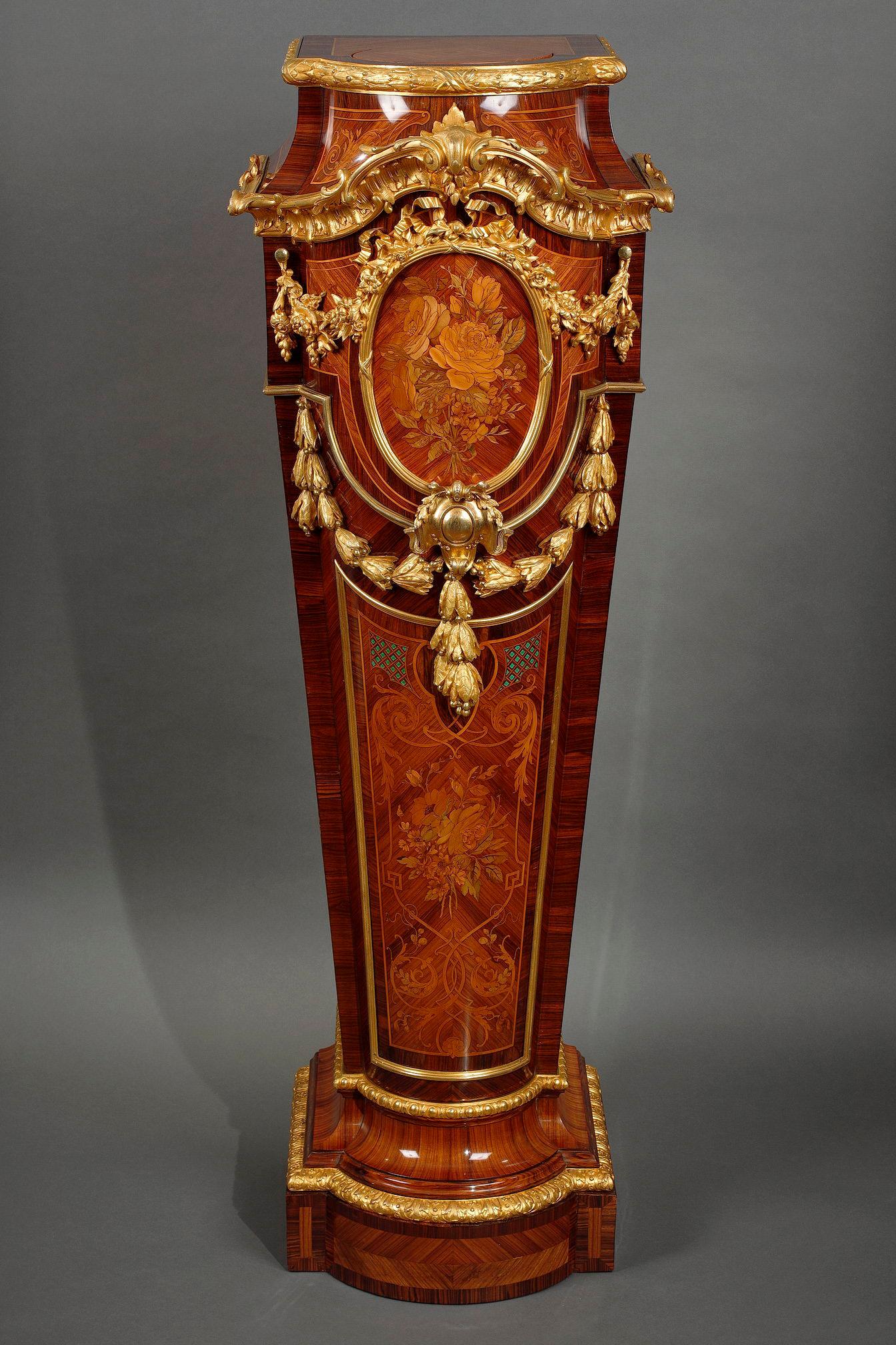Rare Napoleon III display pedestal with curved front, in wood veneer and chiseled and gilded bronze ornamentation. Topped by a rotating circular top underlined by a frieze of laurels, it is decorated on three sides with floral marquetry and
