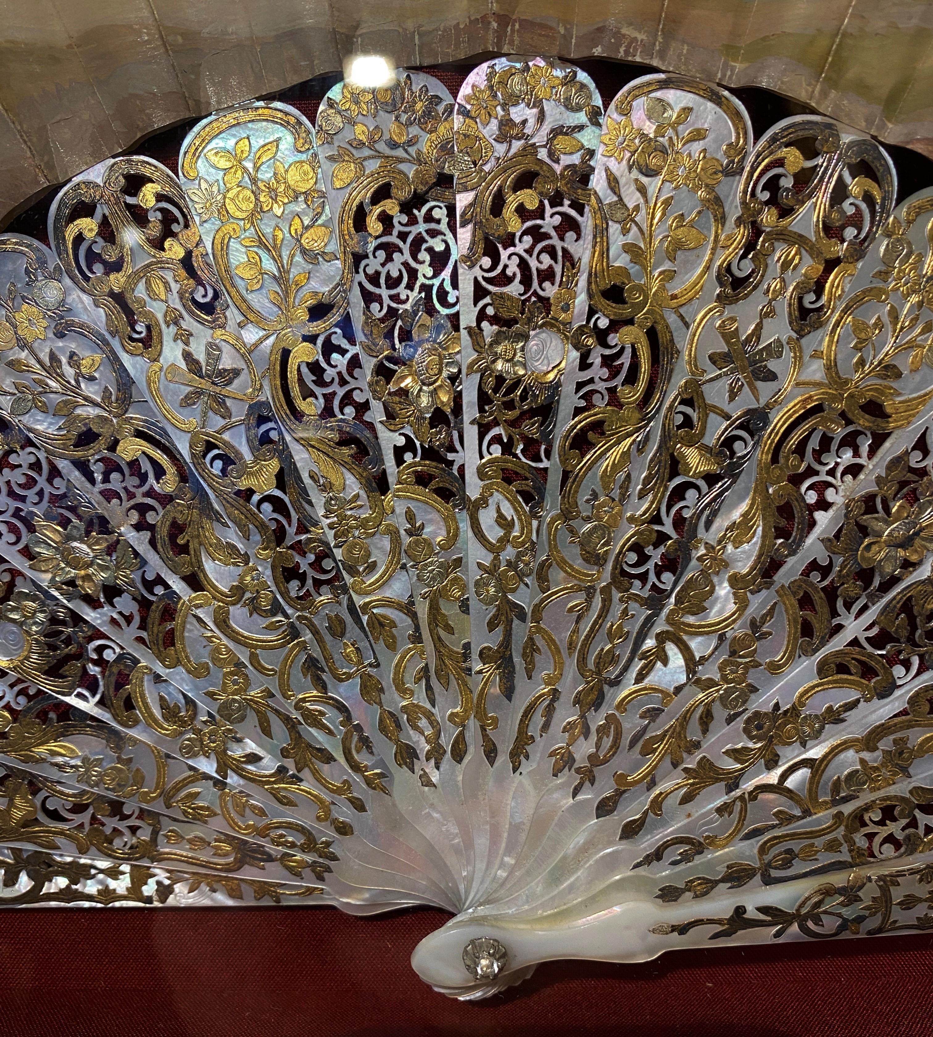 Magnificent fan from the Napoleon III period. Note its very beautiful frame in white mother-of-pearl finely pierced, and applied with gold and silver leaf decorated with flowers and trophies. The paper sheet is painted in gouache with gallant scenes