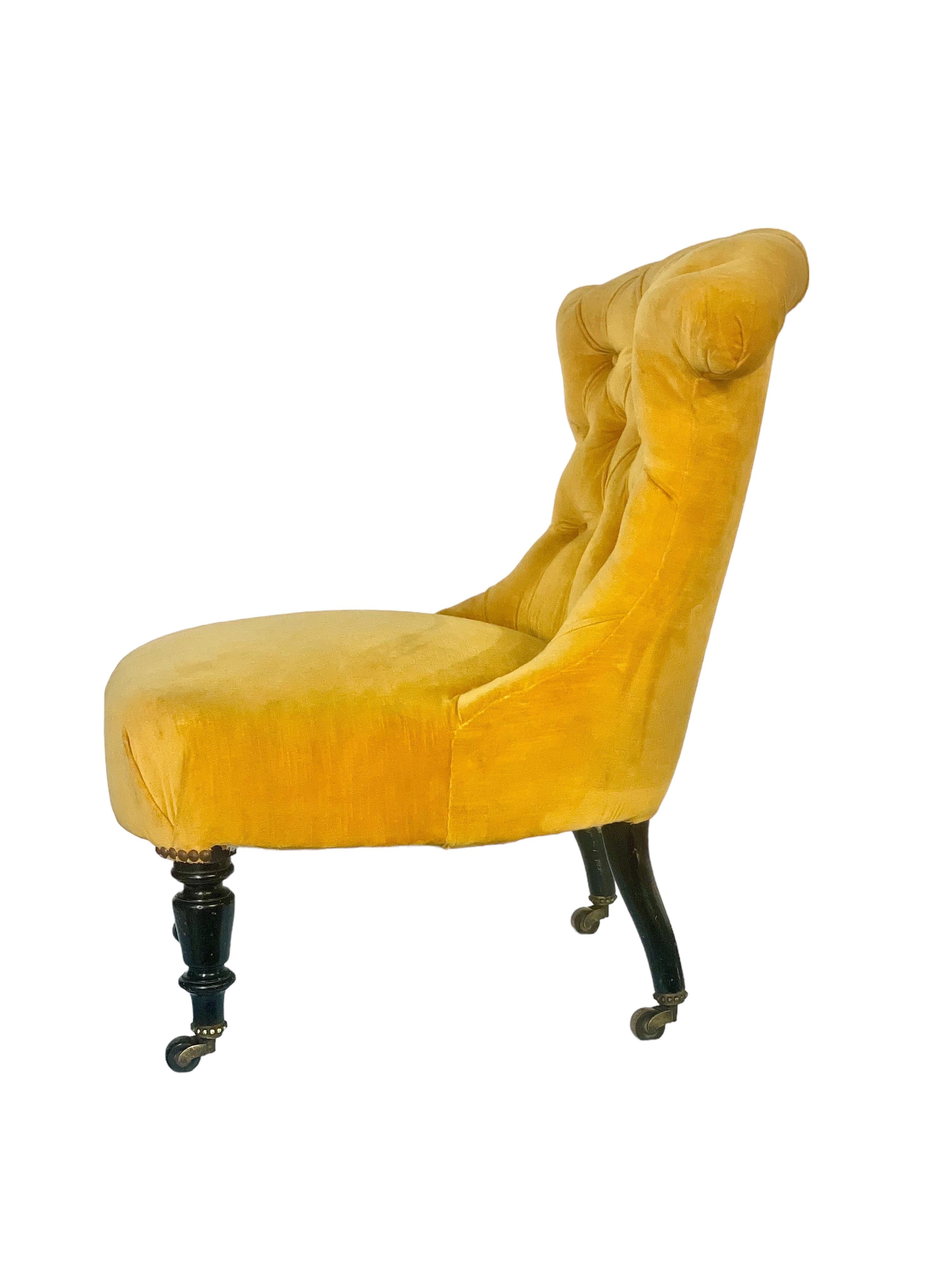 Ein hübscher Napoleon-III-Kaminsessel mit tief geknöpfter Rückenlehne, luxuriöser gelber Samtpolsterung und gefedertem Sitz. Dieser wunderschöne und sehr bequeme Stuhl stammt aus der Zeit um 1860-80 und hat seine schönen originalen ebonisierten