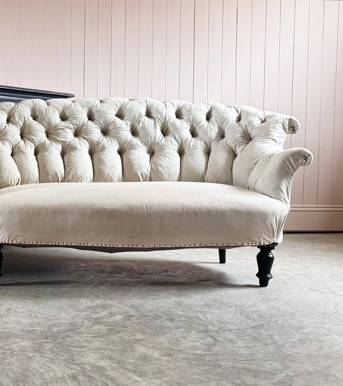 A classic Napoleon III French button back sofa - late 19th Century. Timeless elegance and refined craftsmanship. The sofa features a beautifully shaped, deep button backrest and gently rolled arms.  Original solid wood frame, this has not been