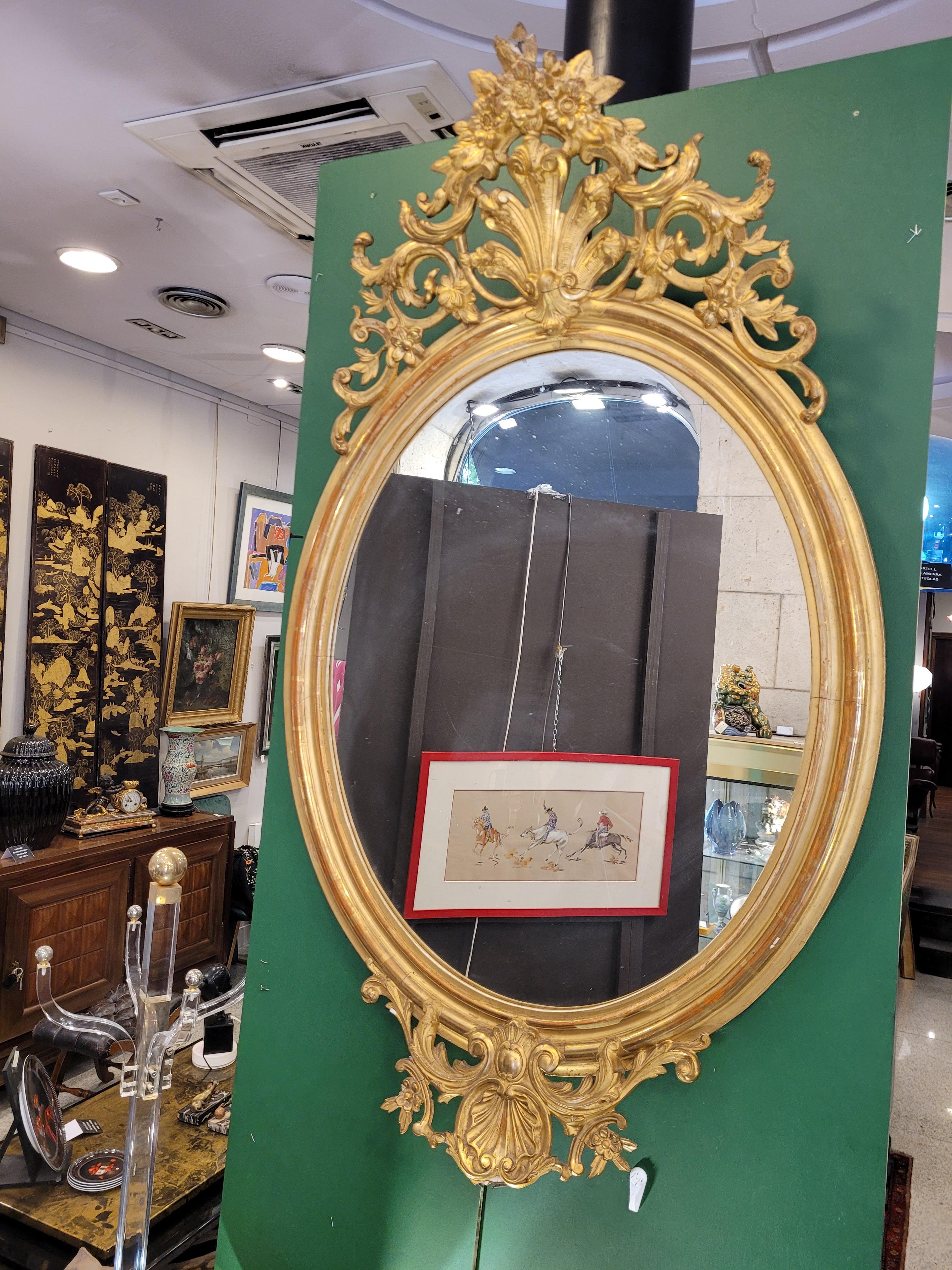 Mirror from the time of Napoleon III, with an ornate gilt carved wood on its upper part, and on the lower part
The highest point of this decorative object is adorned with a spectacular rockery embellished with scrollwork and carved flowers. In the