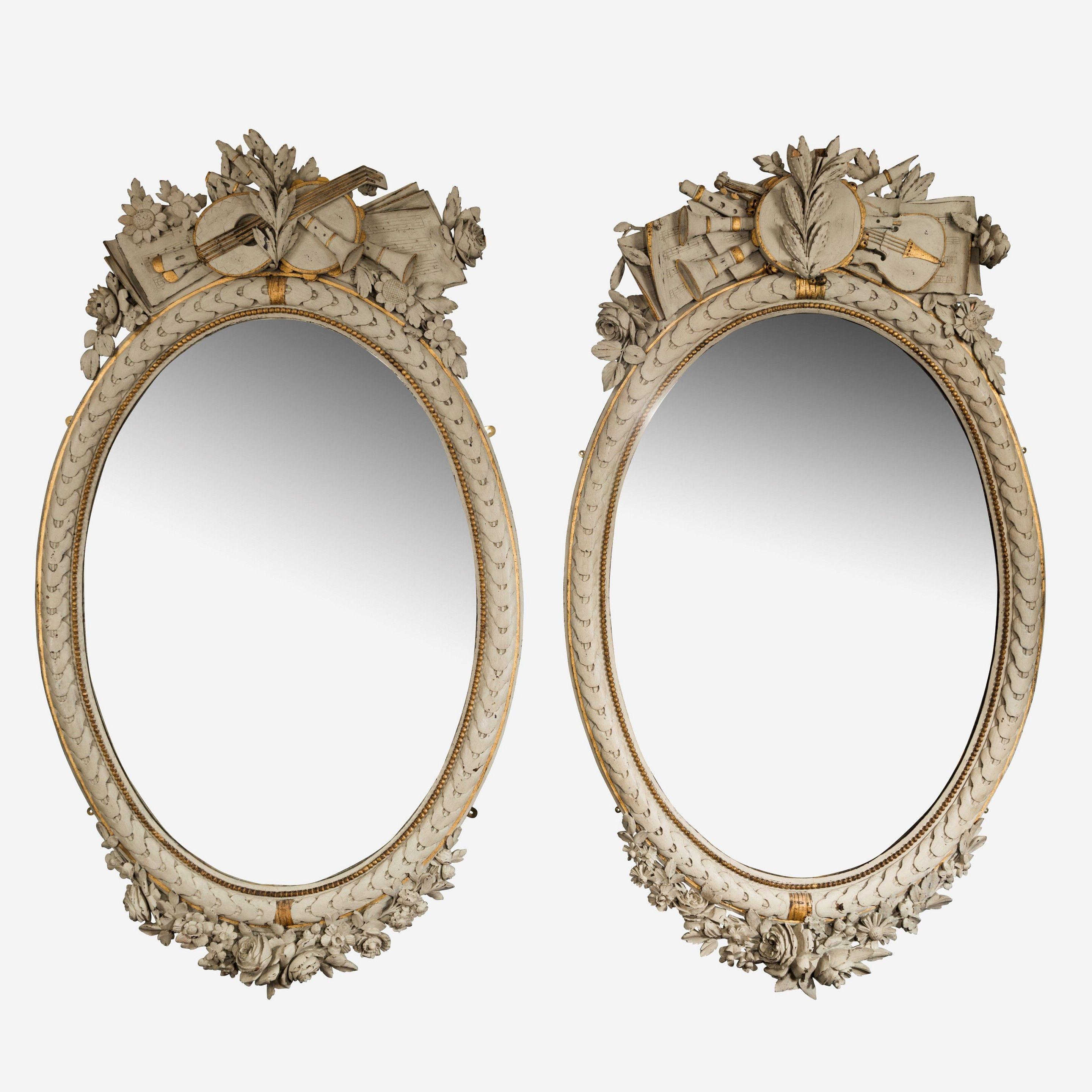 Une grande paire de miroirs ovales français de style Napoléon III. L'écusson est sculpté en bois et représente les arts avec des partitions et des instruments.
