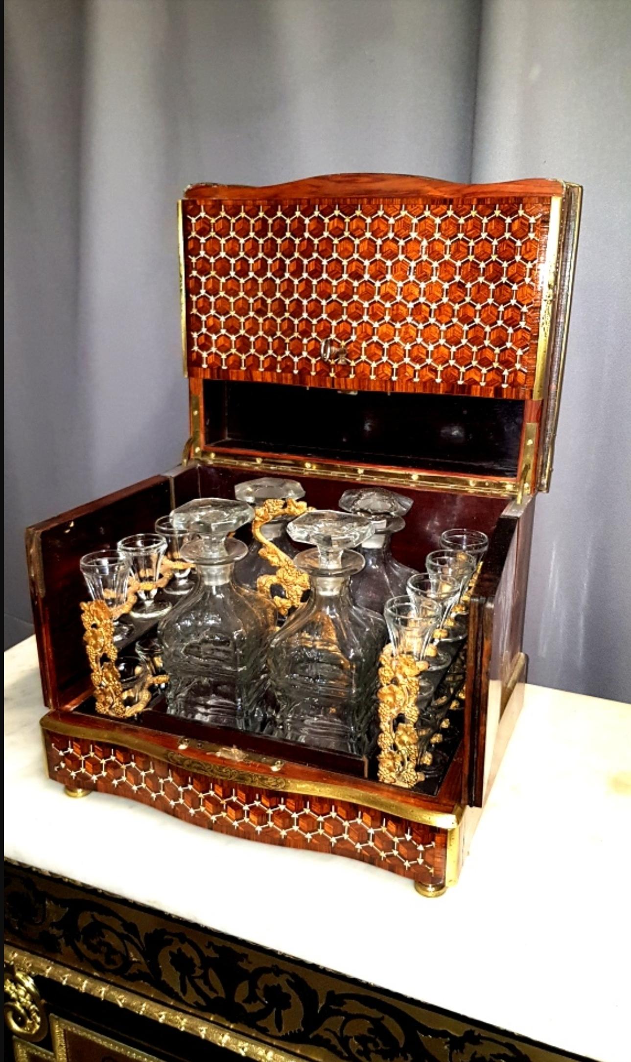 Beautiful liquor cellar cave in marquetry made in fruitwood, geometric patterns on the hood and facade. Glassware composed of 4 carafes and 16 glasses in a mahogany and bronze servant.
France, circa 1865. Napoleon III.
In a very good general