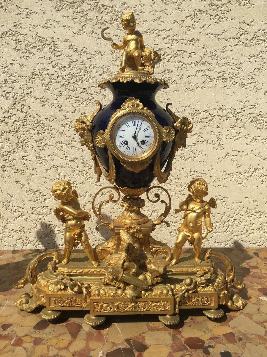 Imposing and magnificent fireplace gilded bronze and blue porcelain vases. The clock is decorated with putti representing the 4 seasons. It is surmounted by a blue porcelain vase, itself dressed with heads of faunas and draped gilded bronze. In the