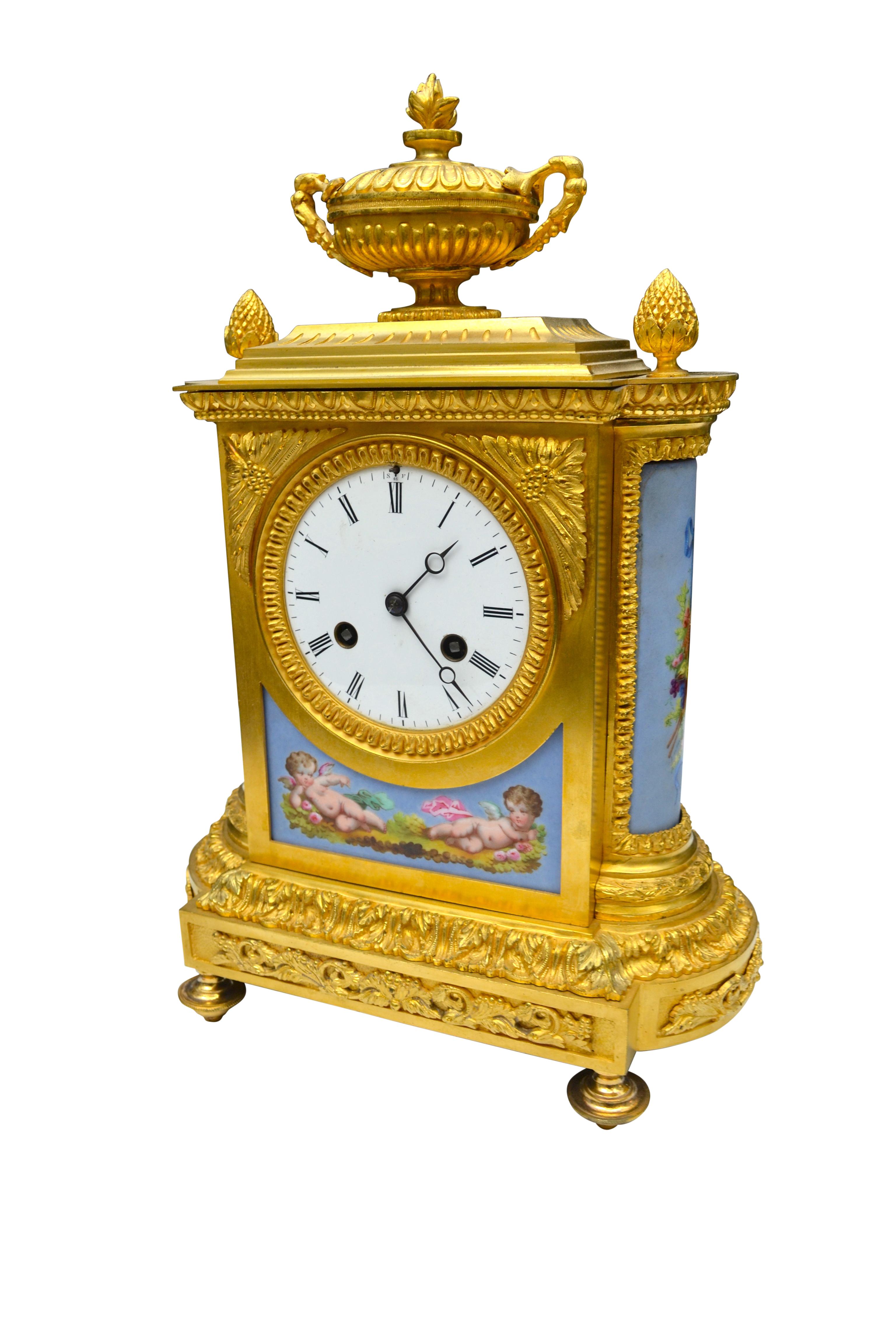 A fine quality Napoleon III gilt bronze and porcelain clock. The sea blue porcelain panels to the sides and front are well painted with frolicking putti; the case surmounted with a pineapple finials and a decorative gilded urn; the large white
