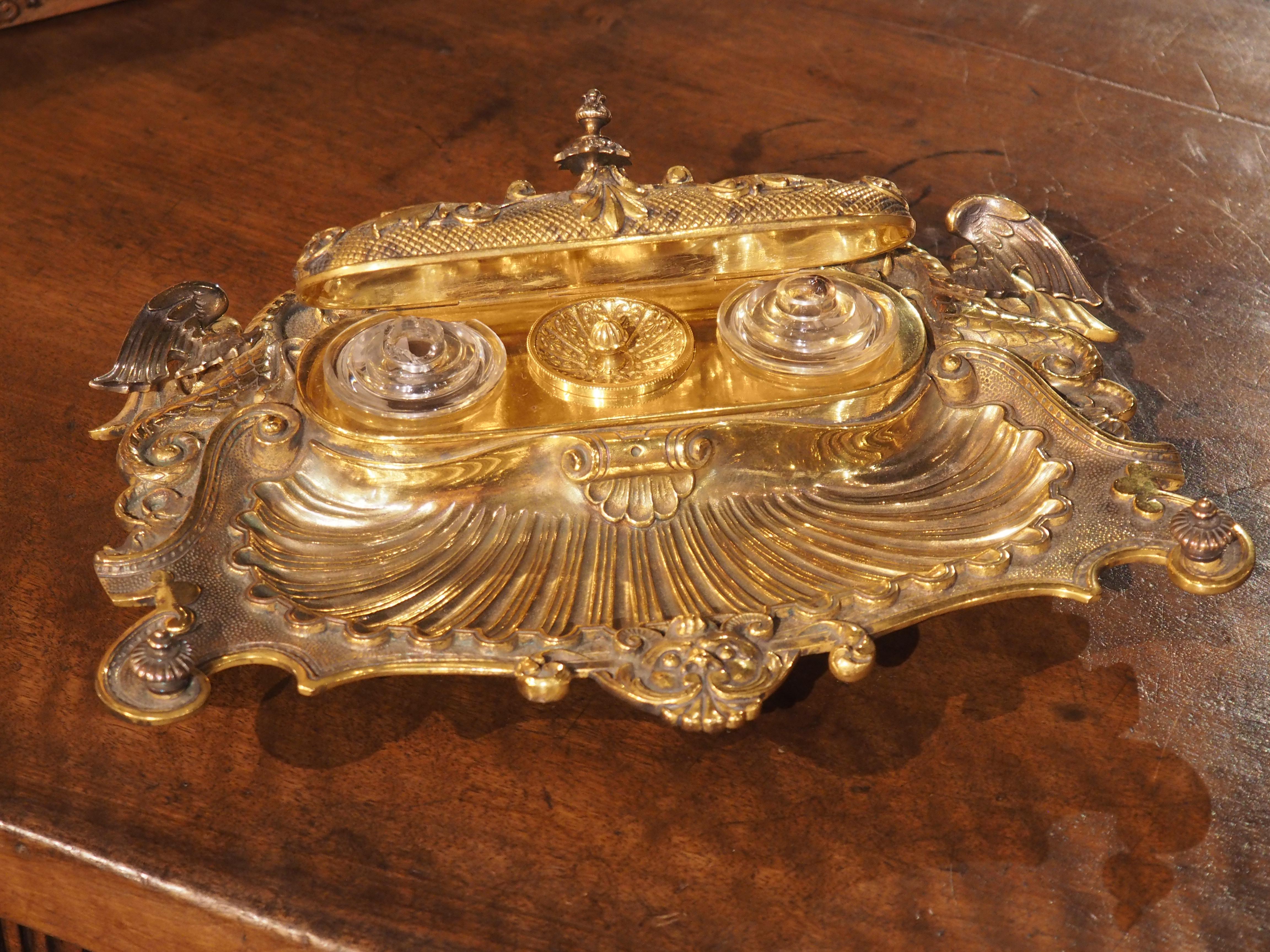 This piece of nineteenth-century French elegance is sure to be the envy of any collector. The Napoleon III gilt bronze inkwell is a prized find, crafted in circa 1840 France with intricate embellishments including a recessed scalloped shell body and