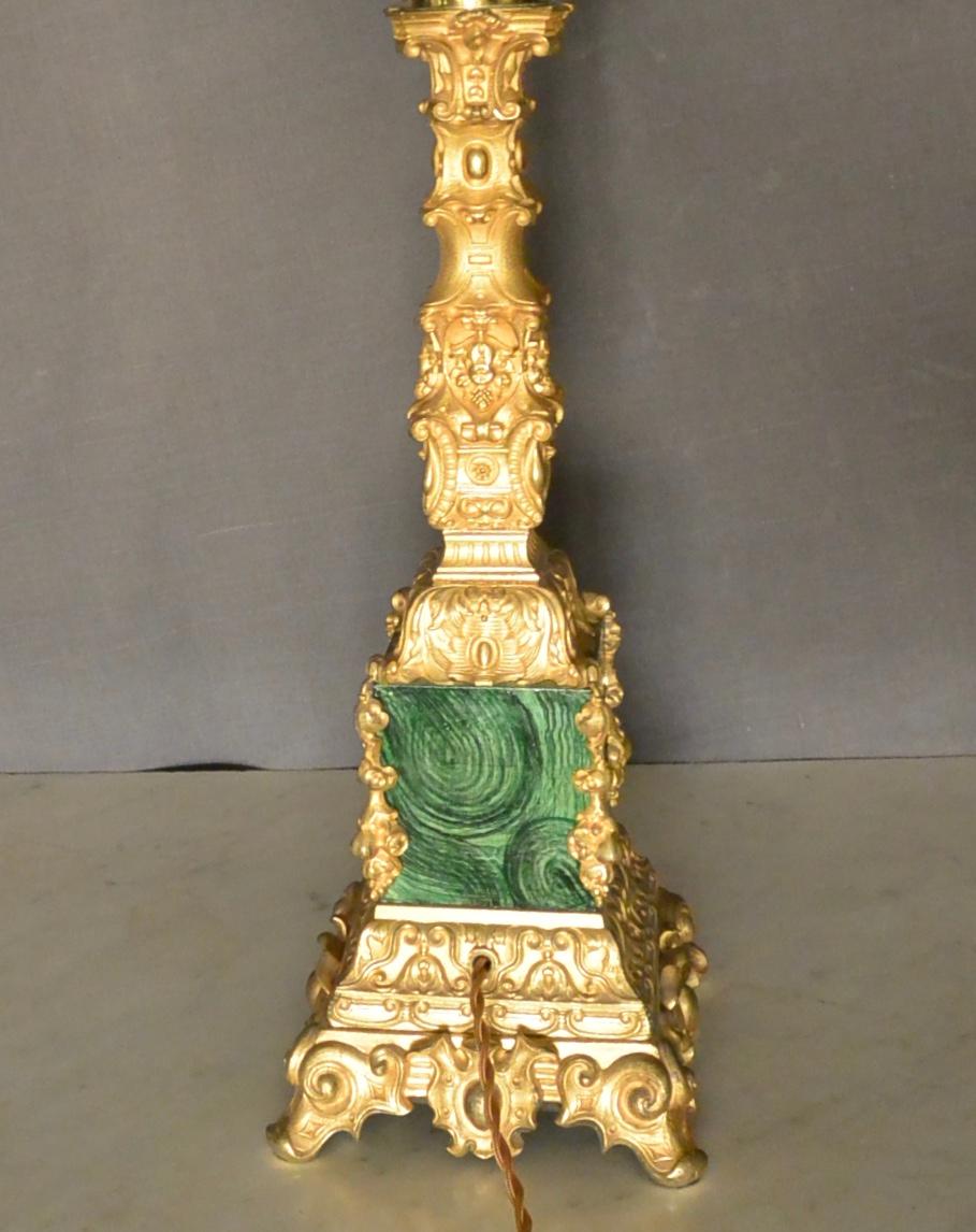 Lampe à colonne Napoléon III en bronze doré et malachite. Lampe à colonne en bronze doré dans une forme richement décorative popularisée dans les années 1860-1870 en France. La base dorée se termine par quatre pieds à volutes, soutenant la section