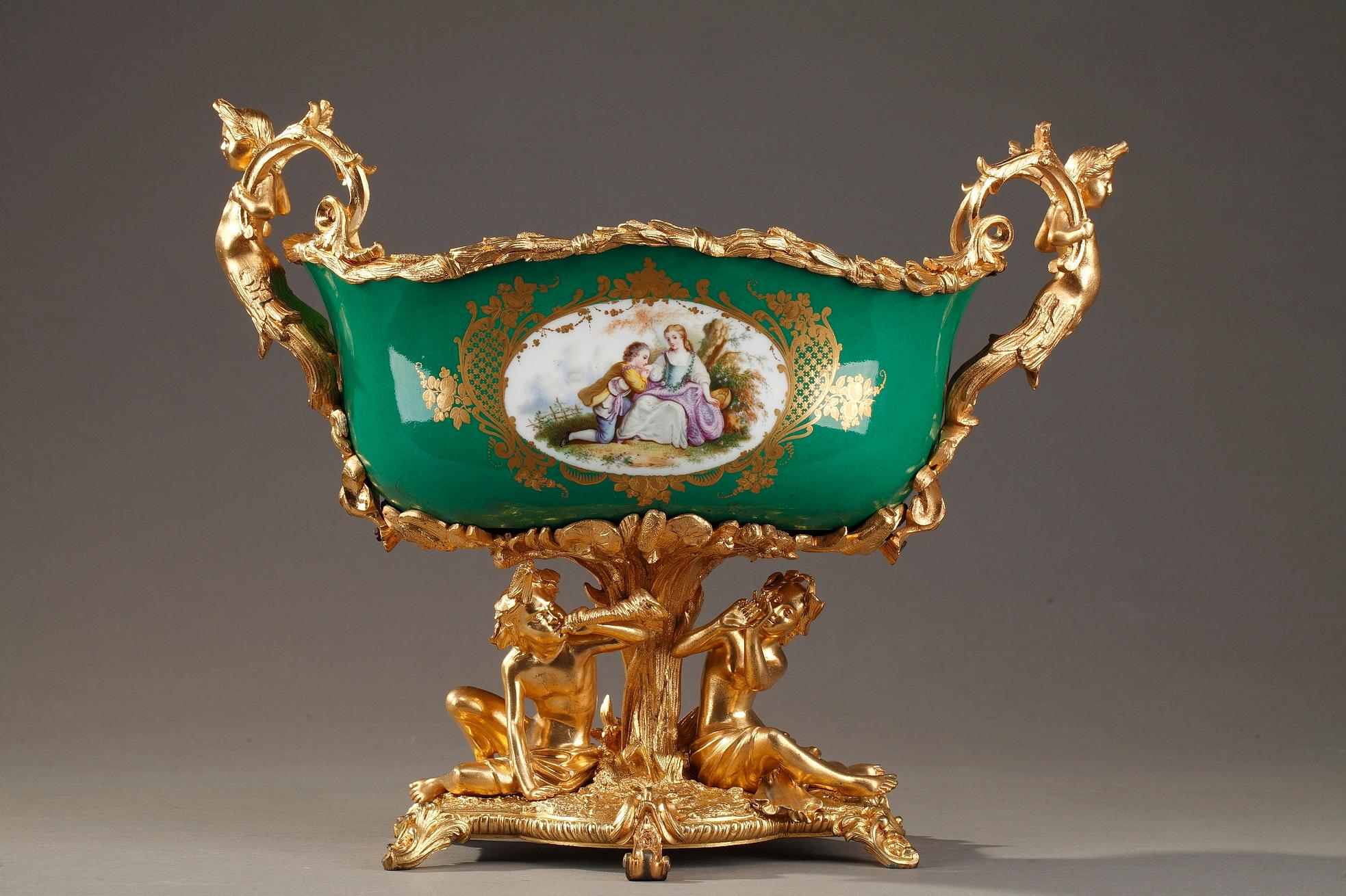 French 19th century gilt bronze-mounted porcelain jardinière. It is decorated on the exterior with a couple in a landscape on one side and with a bird on a branch on the other side. The interior of the jardinière is highlighted with a polychromatic
