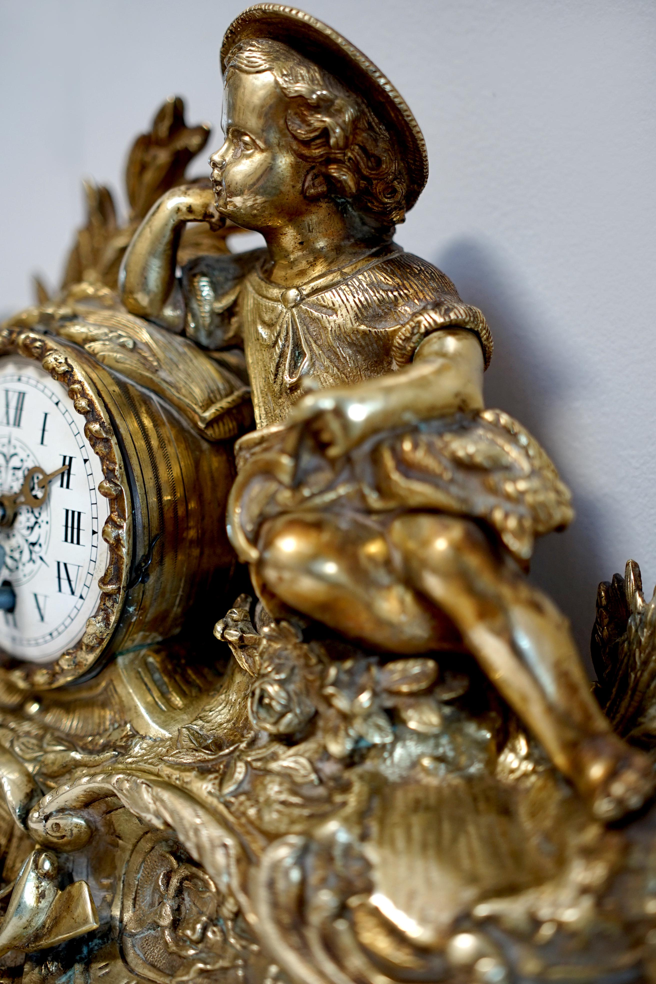 This is a wonderful Napoleon III ormolu mantle clock from the estate of a Los Angeles collector from around 1860.  There is a zaftig little boy perched at the top of the clock, and from his chubby legs, I would say he is eating his fill of baked