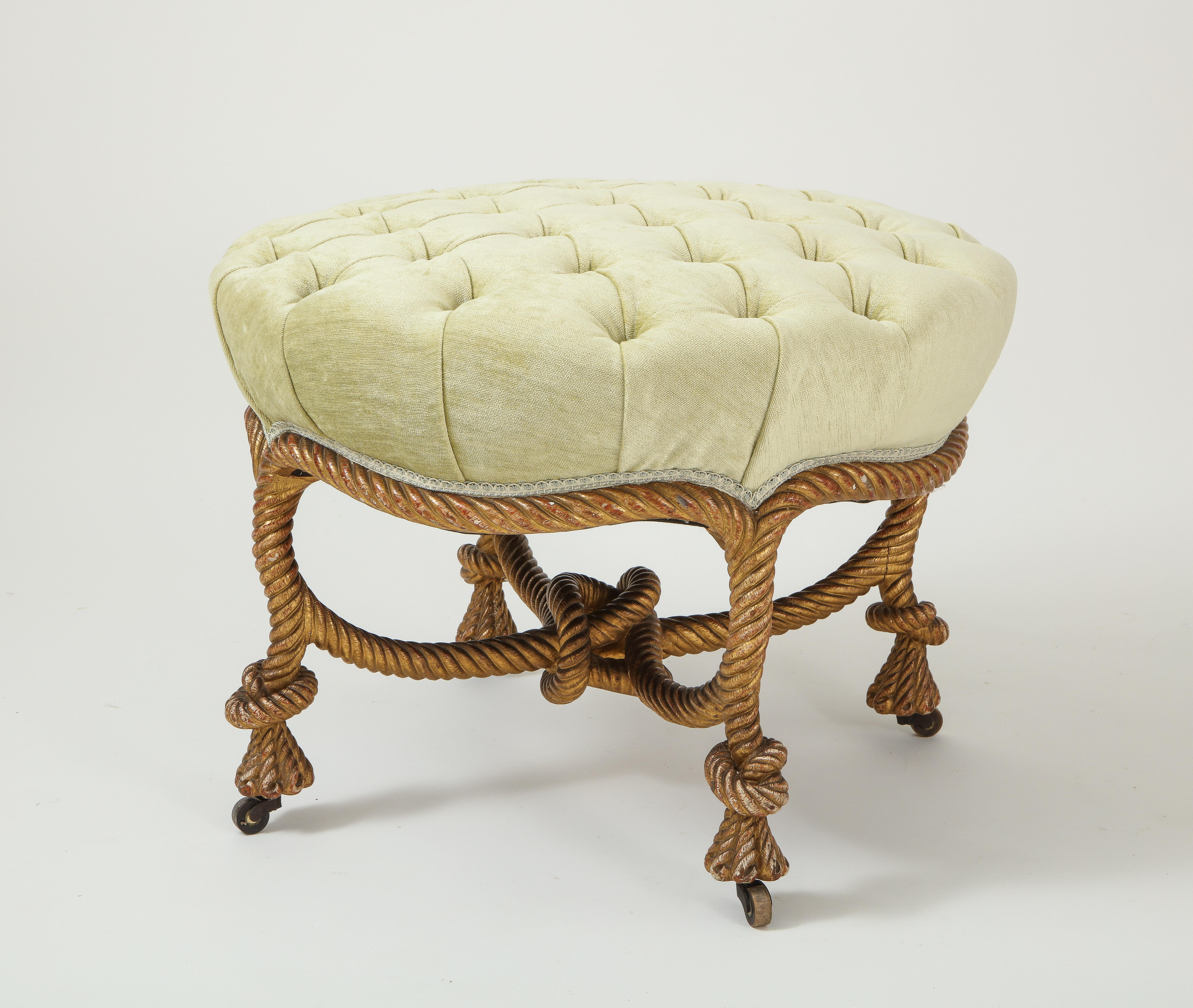 The tufted round seat upholster in apple green velvet, raised on rope carved legs joined by an X-form stretcher centered by a knot, on casters.