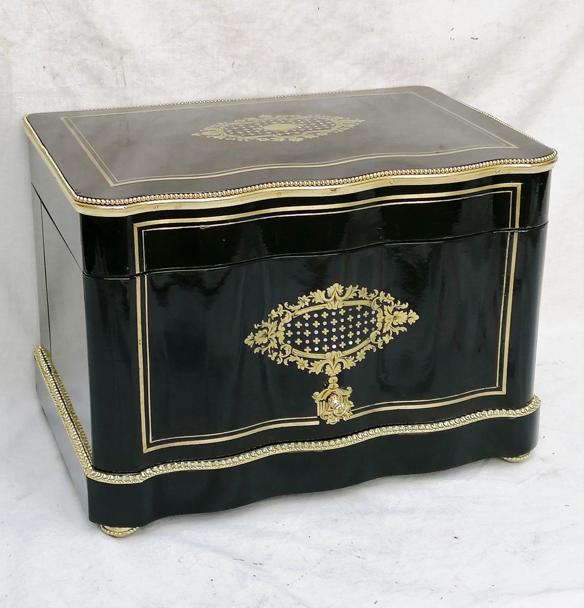 Napoleon III liquor cellar in Boulle style marquetry made in blackened fruit wood with marquetry inlays in brass
with brass cartridges and mother of pearl marquetry.
Gilt bronze fittings in ingot mold, feet and key. Very elegant mahogany and