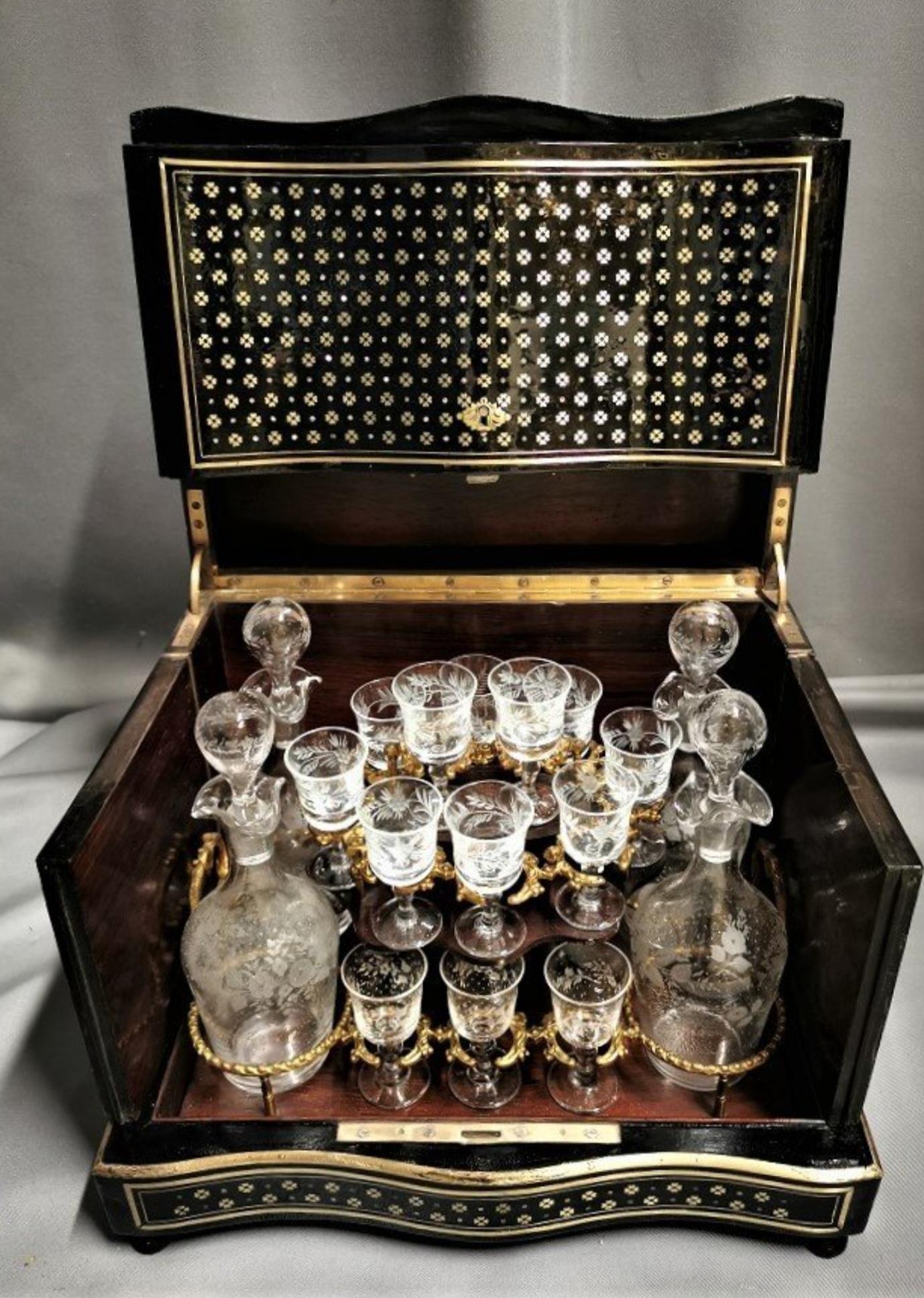 Napoleon III Liquor cellar in Boulle marquetry, beautifully made up by interlacing geometric patterns in the shape of brass quartefeuilles and embedded mother of pearl points, on the hood and the front.
Interior with a removable servant garnished