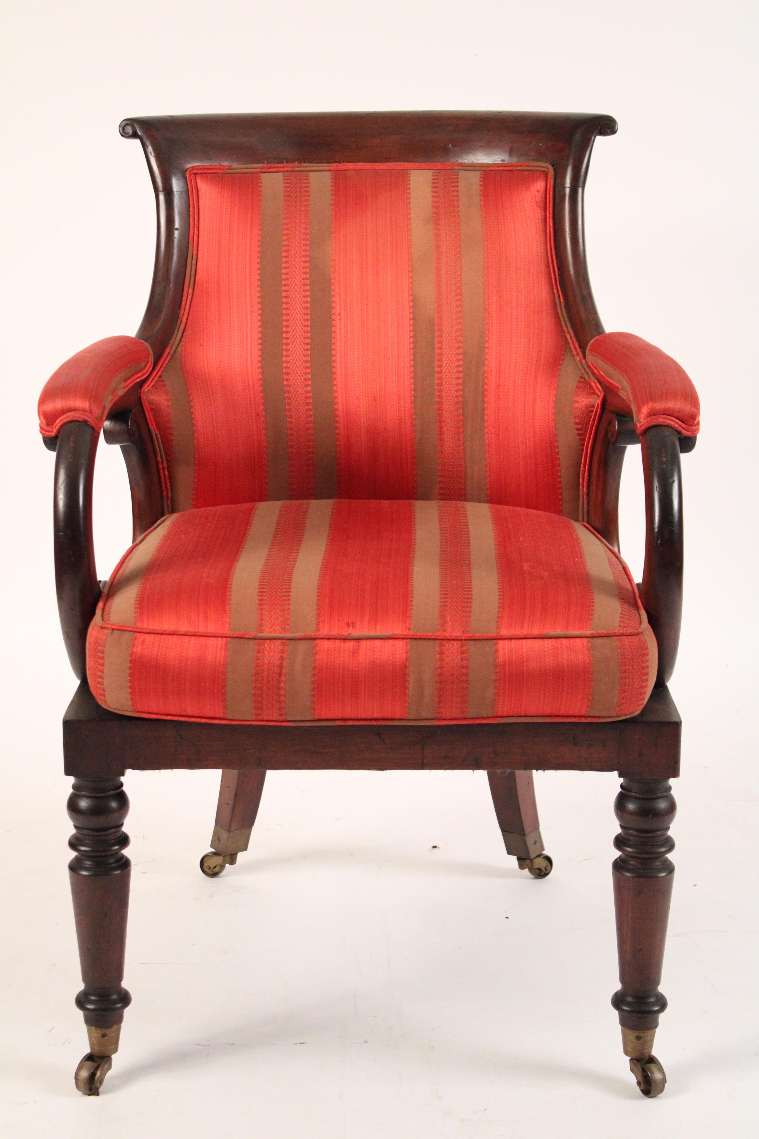 Napoleon III mahogany armchair, circa 1835. Concave shaped crest rail and back making this chair very comfortable, C scrolled arms, turned and tapered front legs ending in brass casters.
