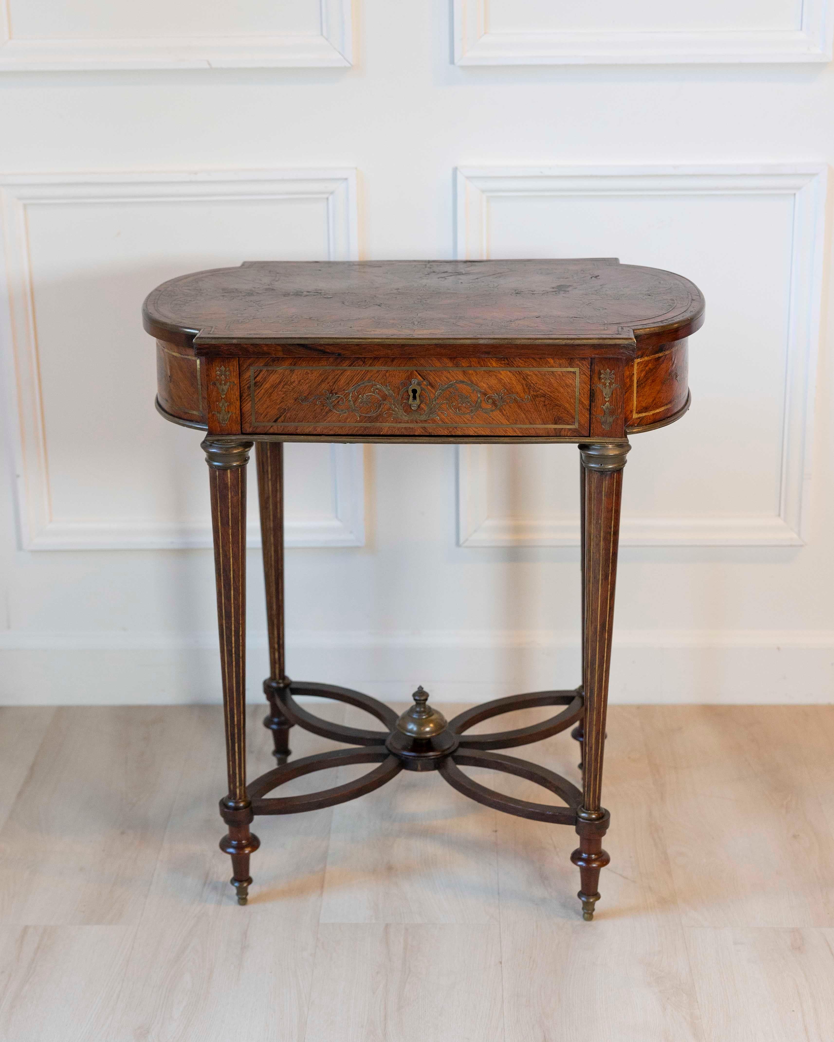 Cette table d'appoint raffinée Napoléon III, datant d'environ 1870, incarne l'élégance et le savoir-faire de la France du XIXe siècle. Le plateau de forme est magnifiquement incrusté de marqueterie, représentant un vase central de fleurs entouré