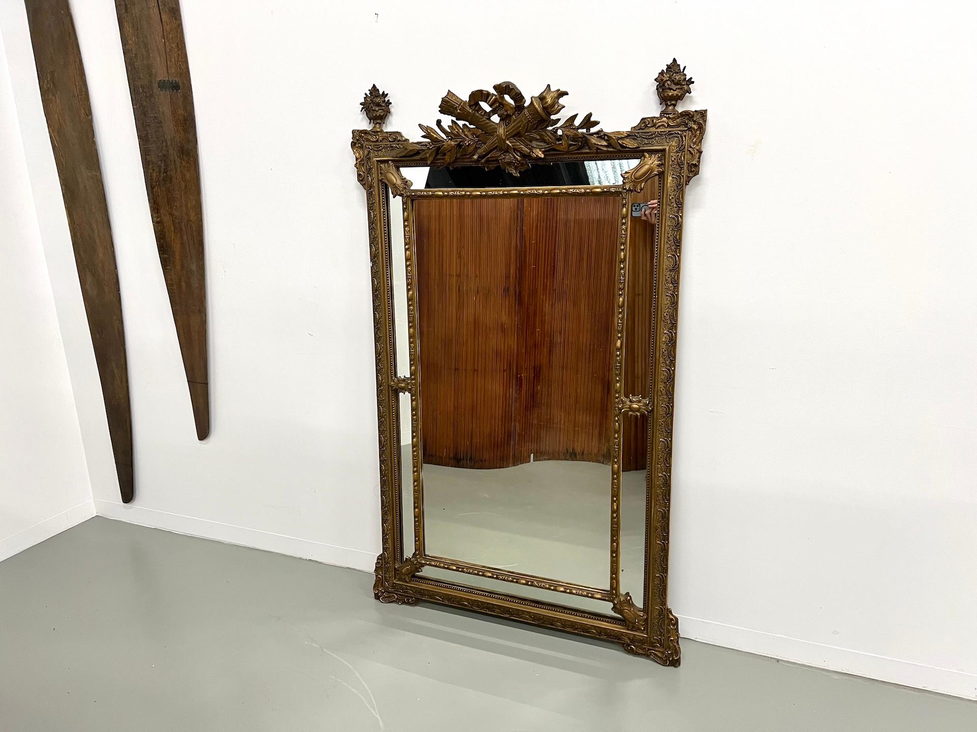 Maison Lecan presents this large Napoleon III mercury mirror (circa 1860–1880), crafted in giltwood and stucco, featuring parecloses and topped with an ornate cresting.

Its decoration, in the Louis XVI revival style so characteristic of the Second