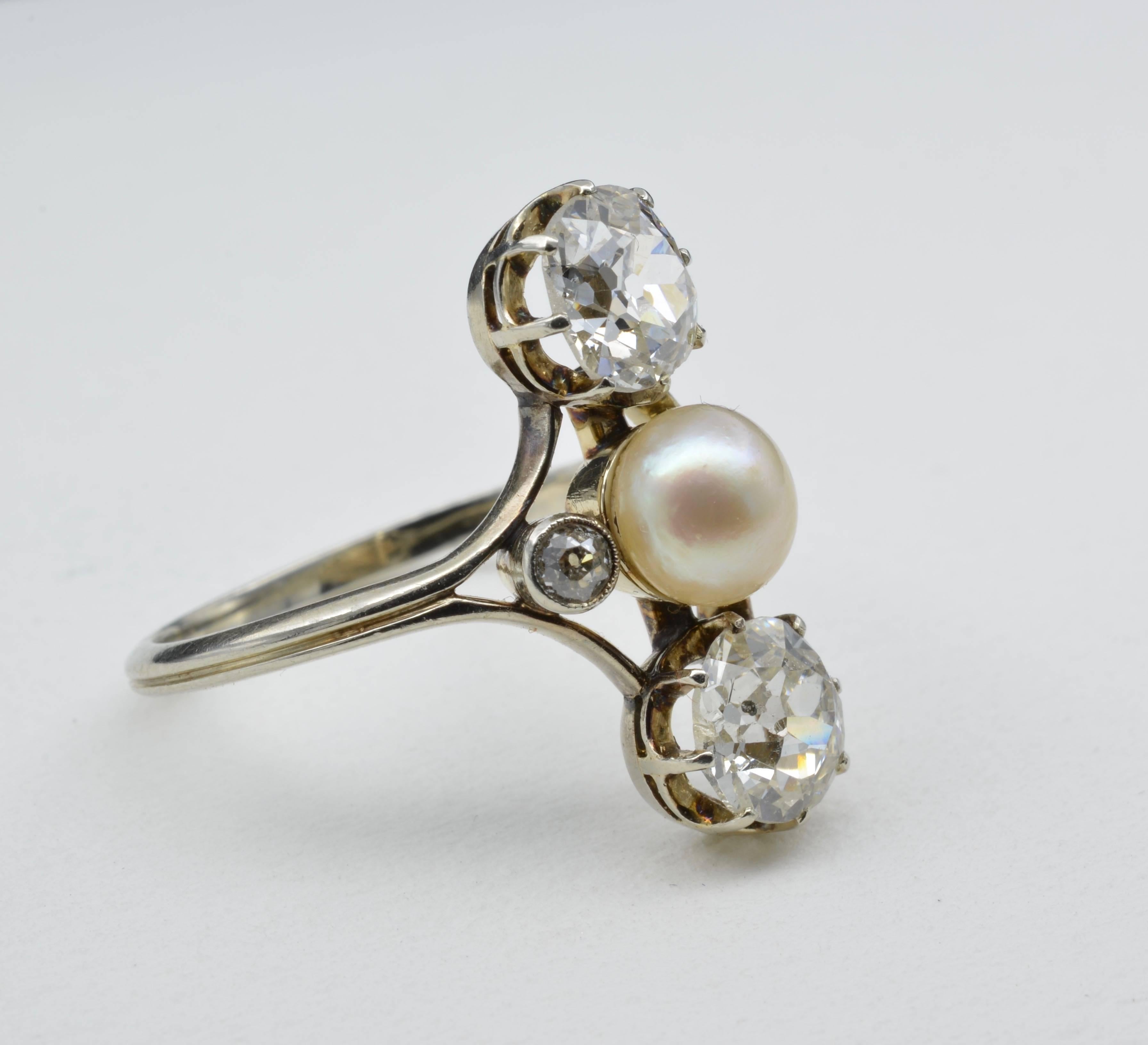 This exquisite ring is from the 1910 Napoleon the III Empire Era and is in a Josephine style. Two superb old mine cut diamonds have a total weight of 2.4 carats and has a central 6.4 mm pearl. There are two accent diamonds which create an allure of