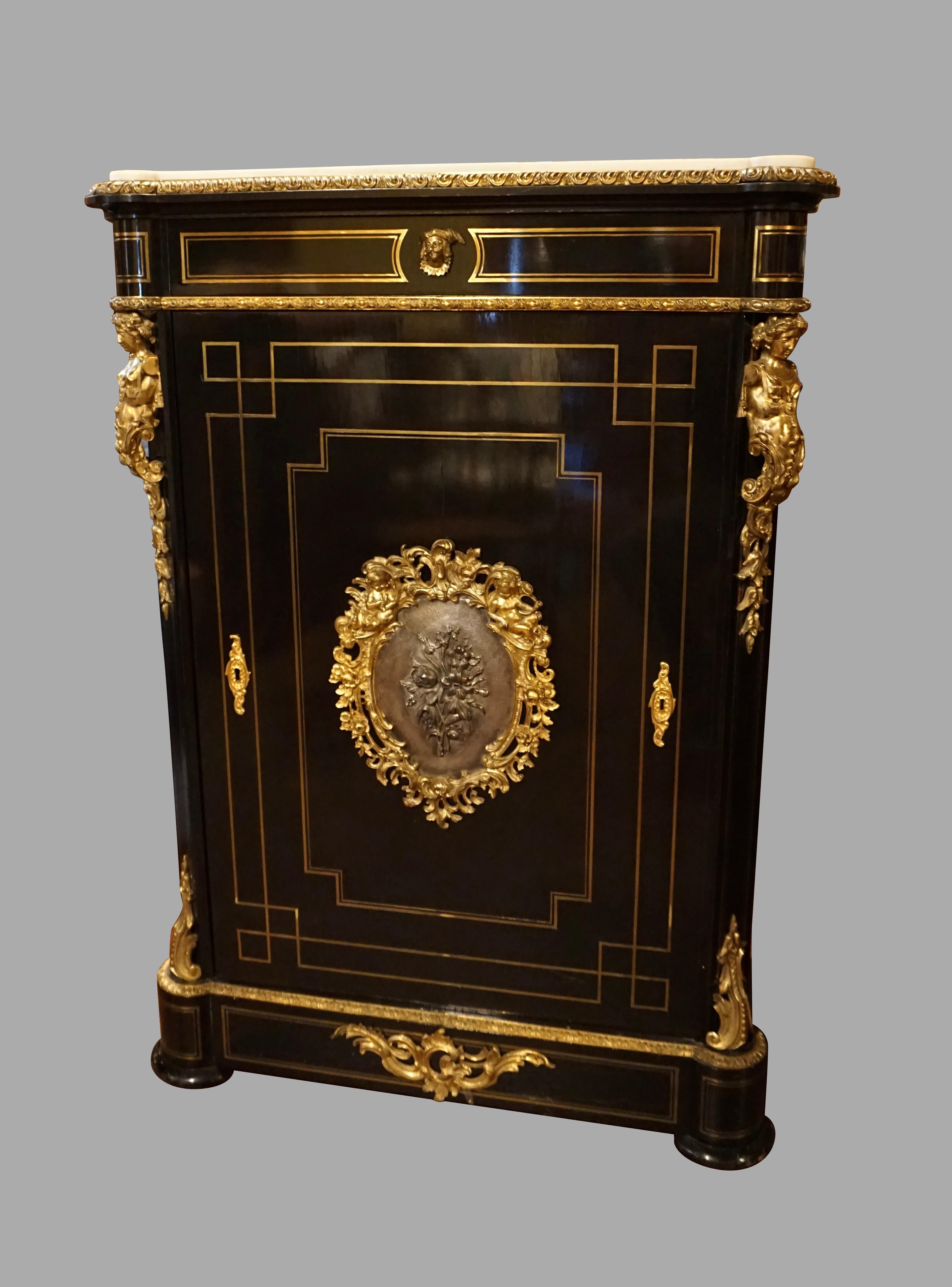 A very good quality French Napoleon III period ebonized beech side cabinet with an inset white carrara marble top, the marble surrounded by an ormolu gadrooned edge above a single cabinet door with a central bronze mounted plaque. The piece is