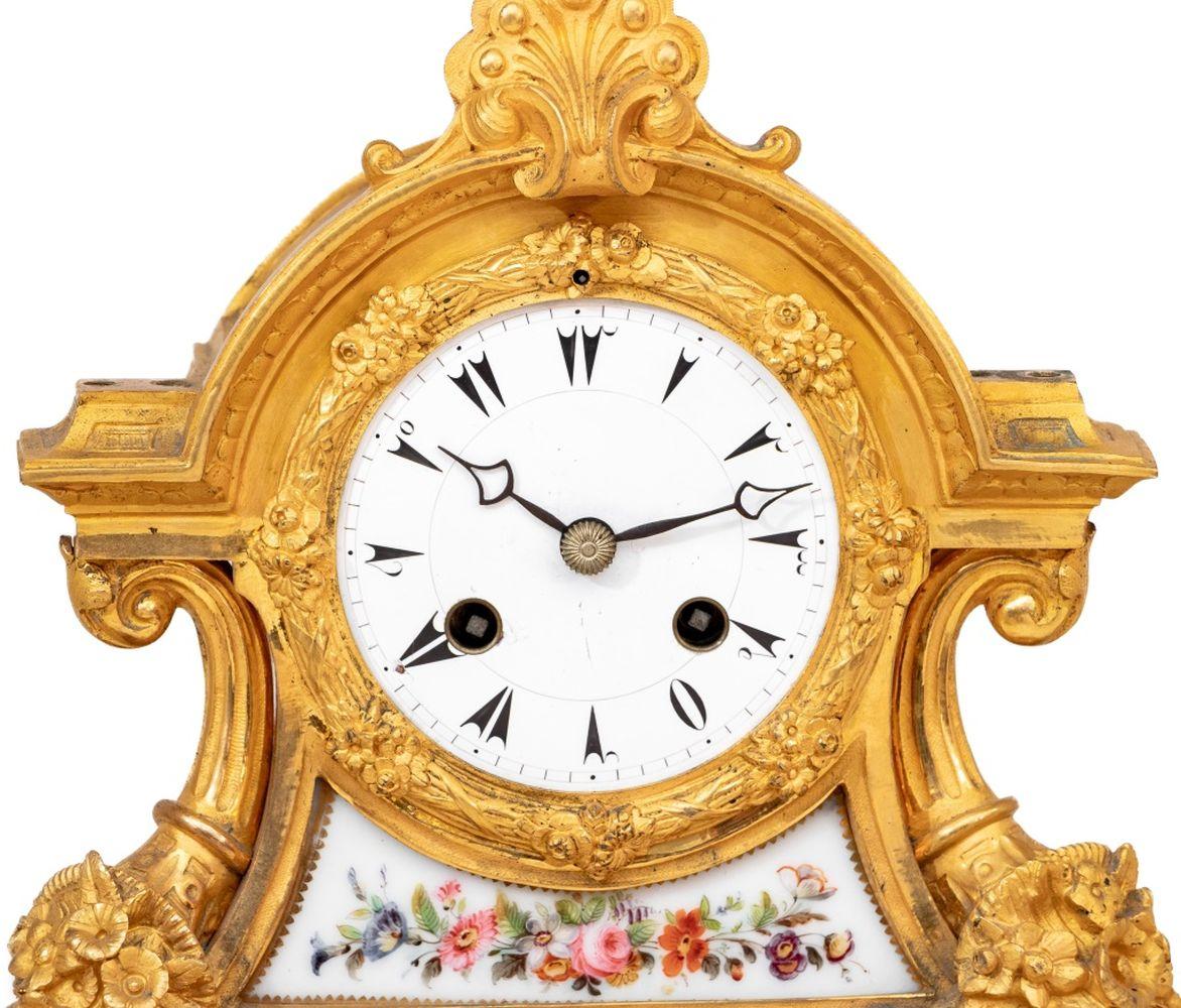 Napoleon III Ormolu and Porcelain Mounted Clock, circa 1860, the white enamel dial with Turkish numerals, the movement strike on bell, surmounted by an urn of flowers, flanked by cornucopae, columnar supports, foliate scrolls, panels of white ground