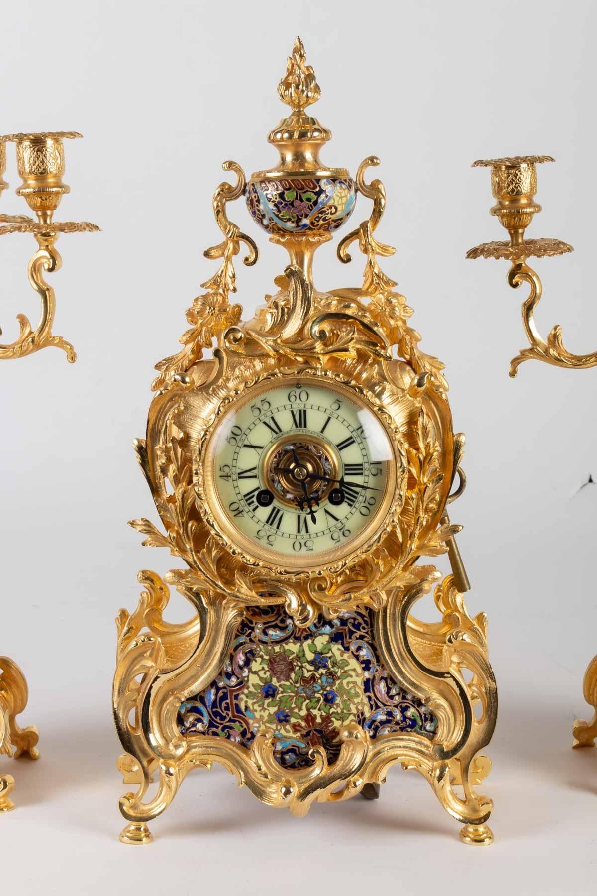 Fireplace set 19th century, composed of a clock and two candelabra, in gilded bronze and cloisonné enamel
Nap III period.
Clock H 45 cm / W 22 cm / D 12 cm
Candelabra H 49 cm / W 26 cm / D 12 cm.