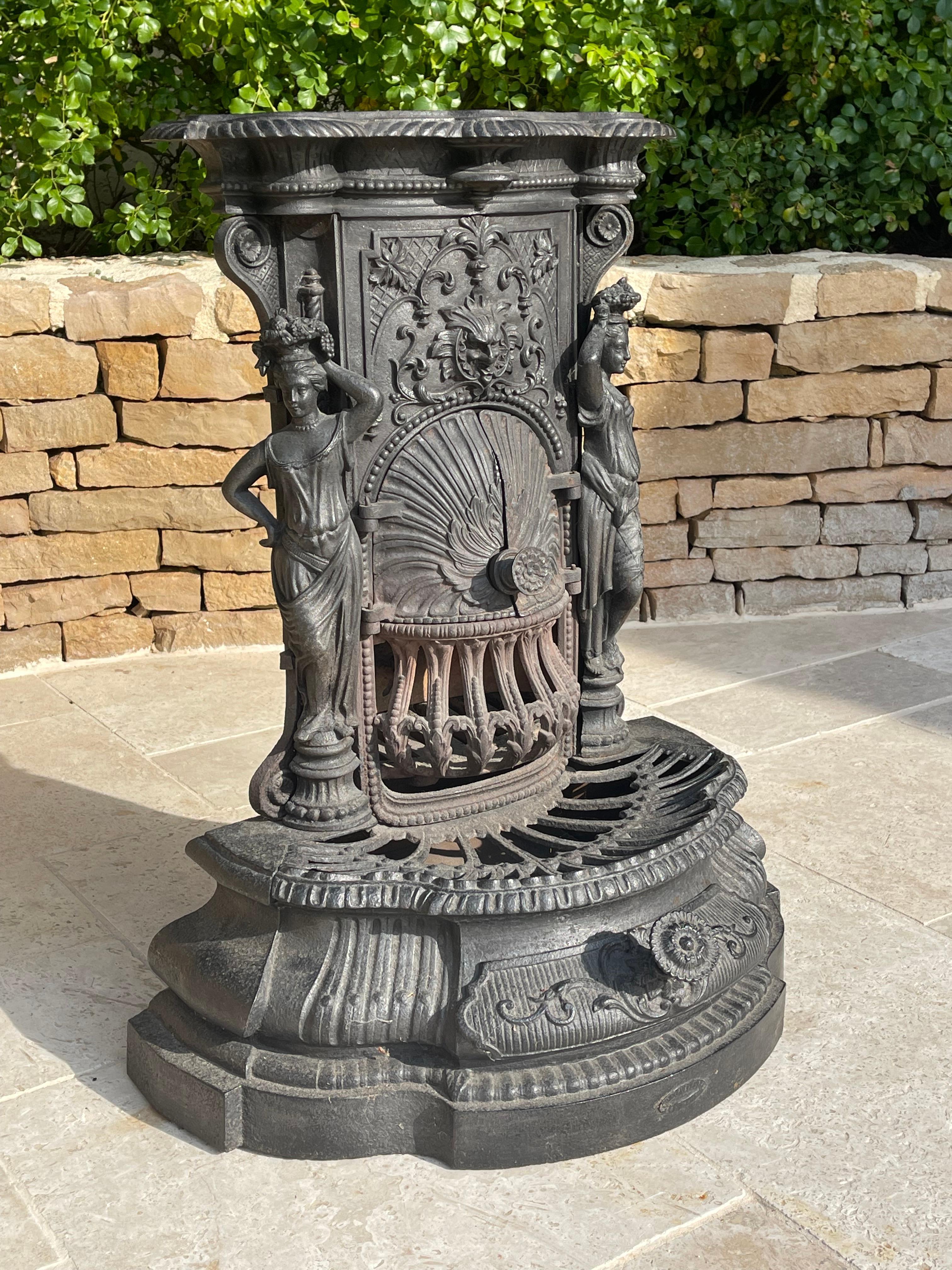Very pretty cast iron stove richly decorated with characters and arabesques, opening with 2 doors and 1 drawer to collect the ashes. Beautiful work inspired by Napoleon III made in the early 1900s. It is in good general condition and can be used as