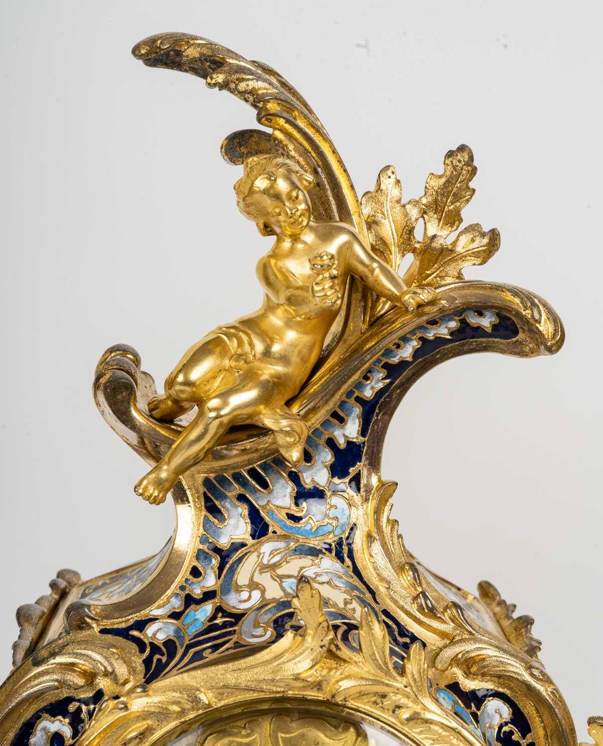 Napoleon III period gilt bronze and enamelled mantel set, 19th century.

A Napoleon III period mantel set with its clock and two candelabras in gilt bronze, enamelled and cloisonné.
Candelabra: H: 43cm, D: 26cm
Pendulum: H: 40cm, W: 24cm, D: 13cm
