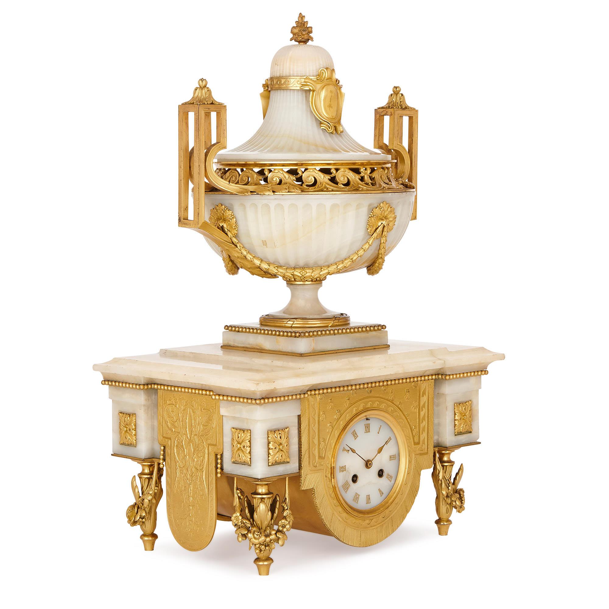 The white onyx and gilt bronze three-piece set consists of a central clock, accompanied by two six-light candelabra. The three items were crafted in the 19th century, during the reign of Napoleon III (1852-1870), and have been attributed to