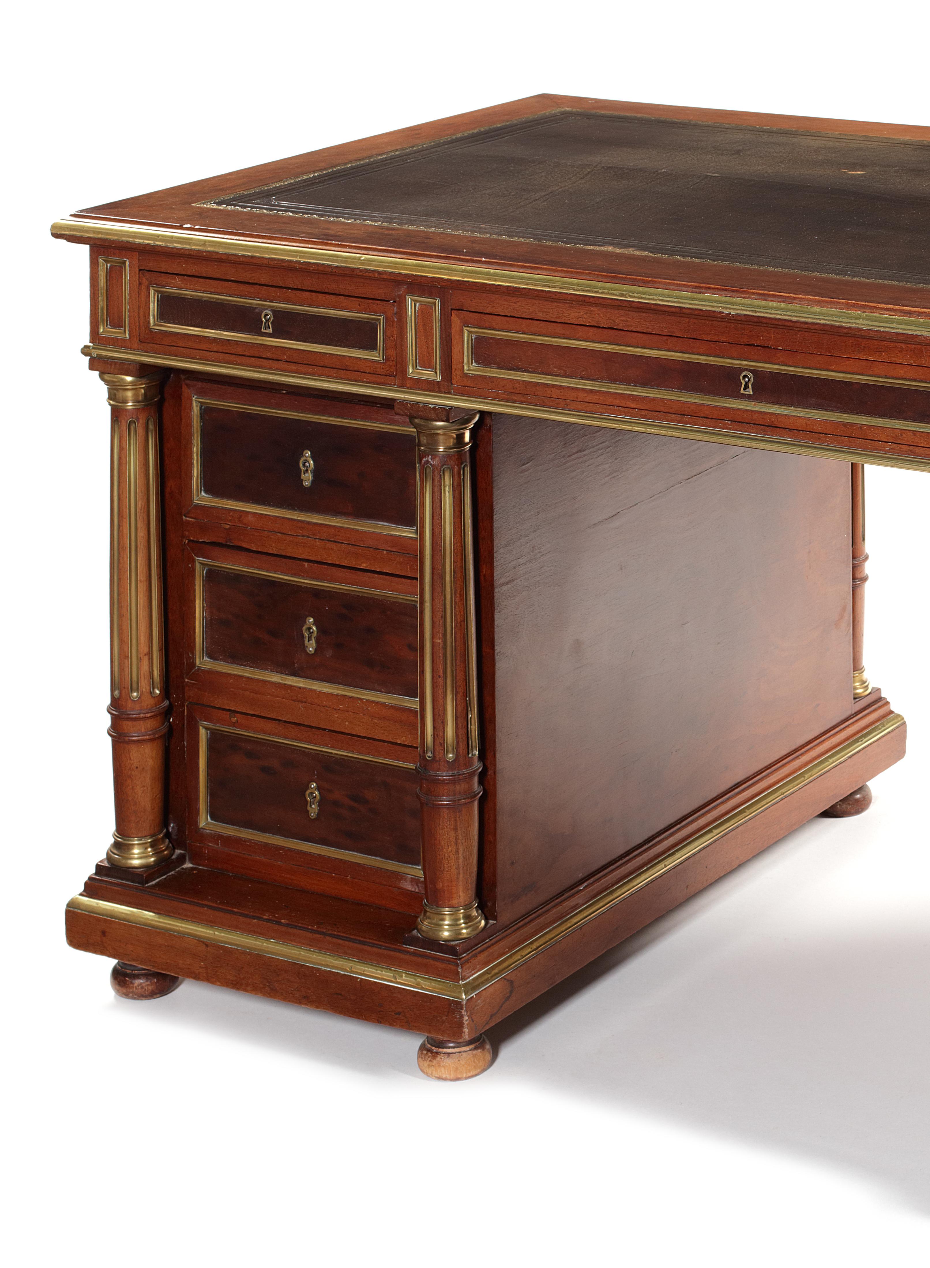 Napoleon III 'plum pudding' mahogany and applied brass pedestal desk
The rectangular moulded top with tooled green and gilt leather, above three frieze drawers, the kneehole flanked by three short drawers to each side flanked by fluted brass