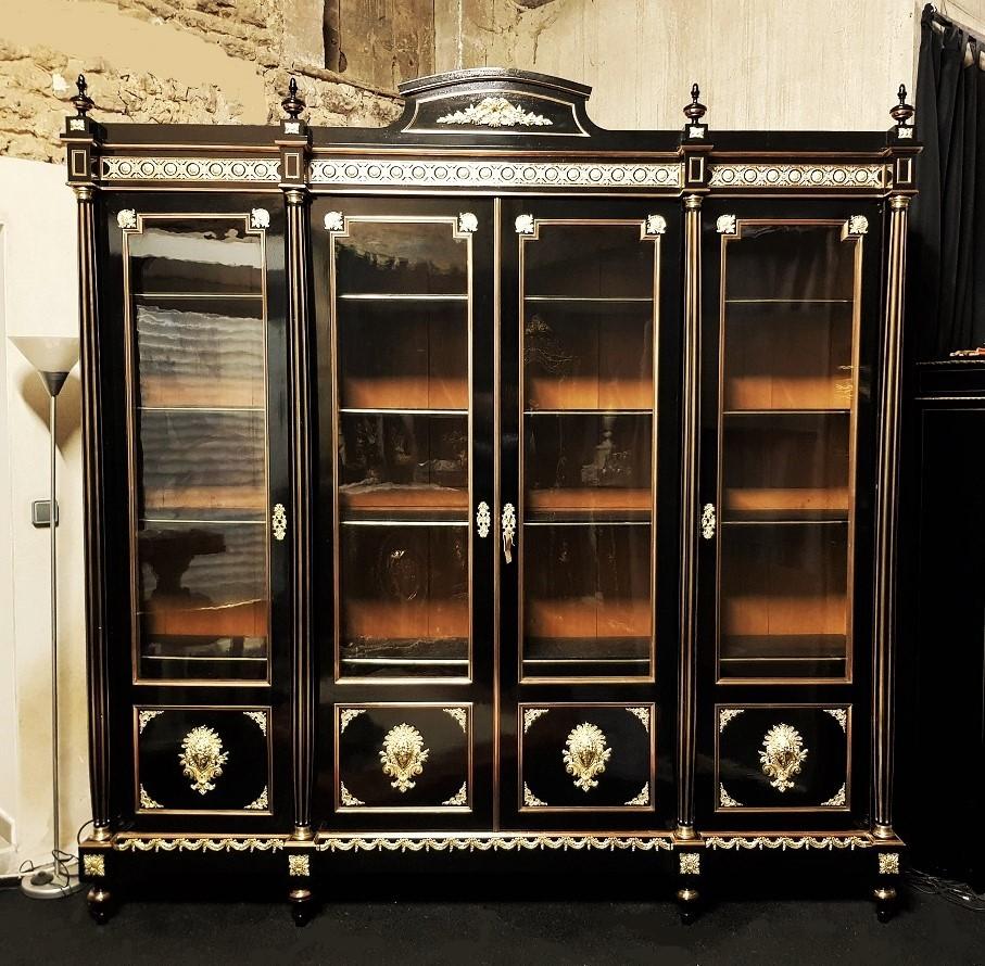 Impressive, rare and large Napoleon III bookcase or cupboard with 4 doors in Boulle marquetry.
Large dimensions, it is composed by 4 doors and 4 detached columns rudentes and decorated with brass grooves. Important ornamentation of gilt bronze with