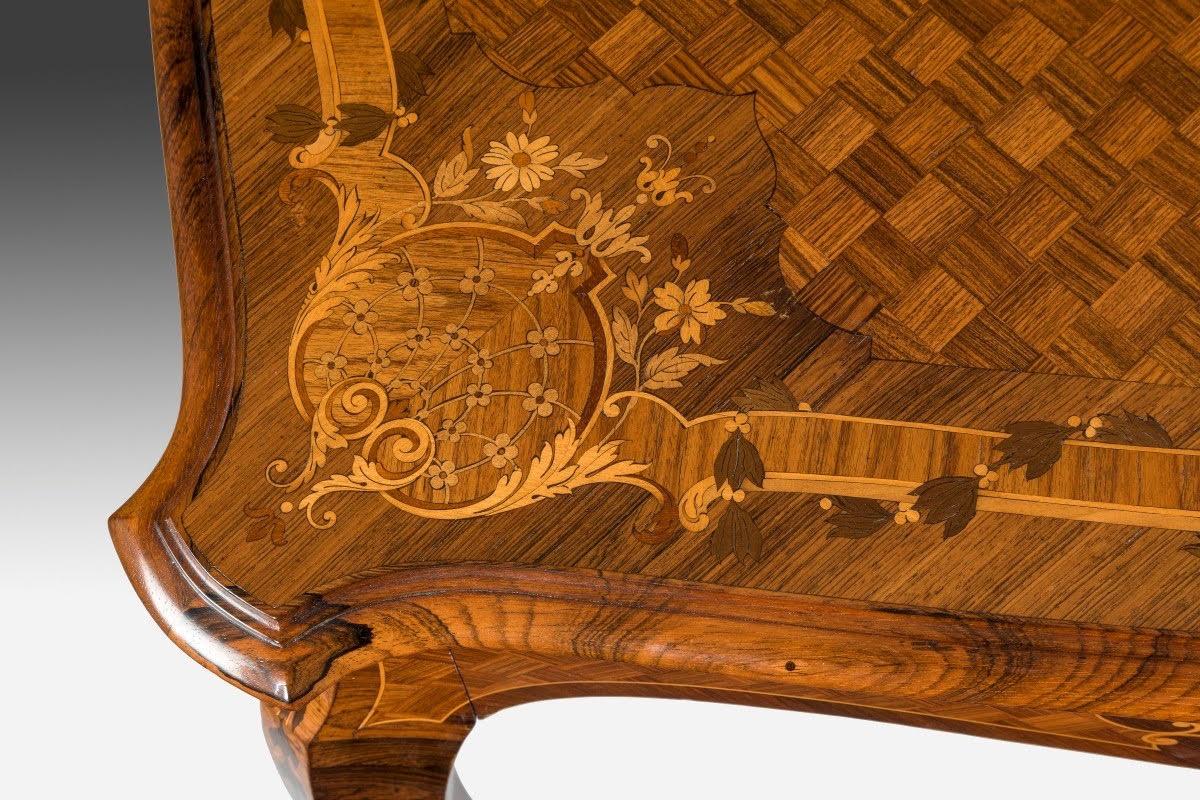 A Napoleon III free-standing rosewood centre table attributed to A Hébert, the serpentine top above a shaped frieze with a long, disguised drawer on one side, the top and sides decorated in kingwood with cube parquetry within a boxwood border with