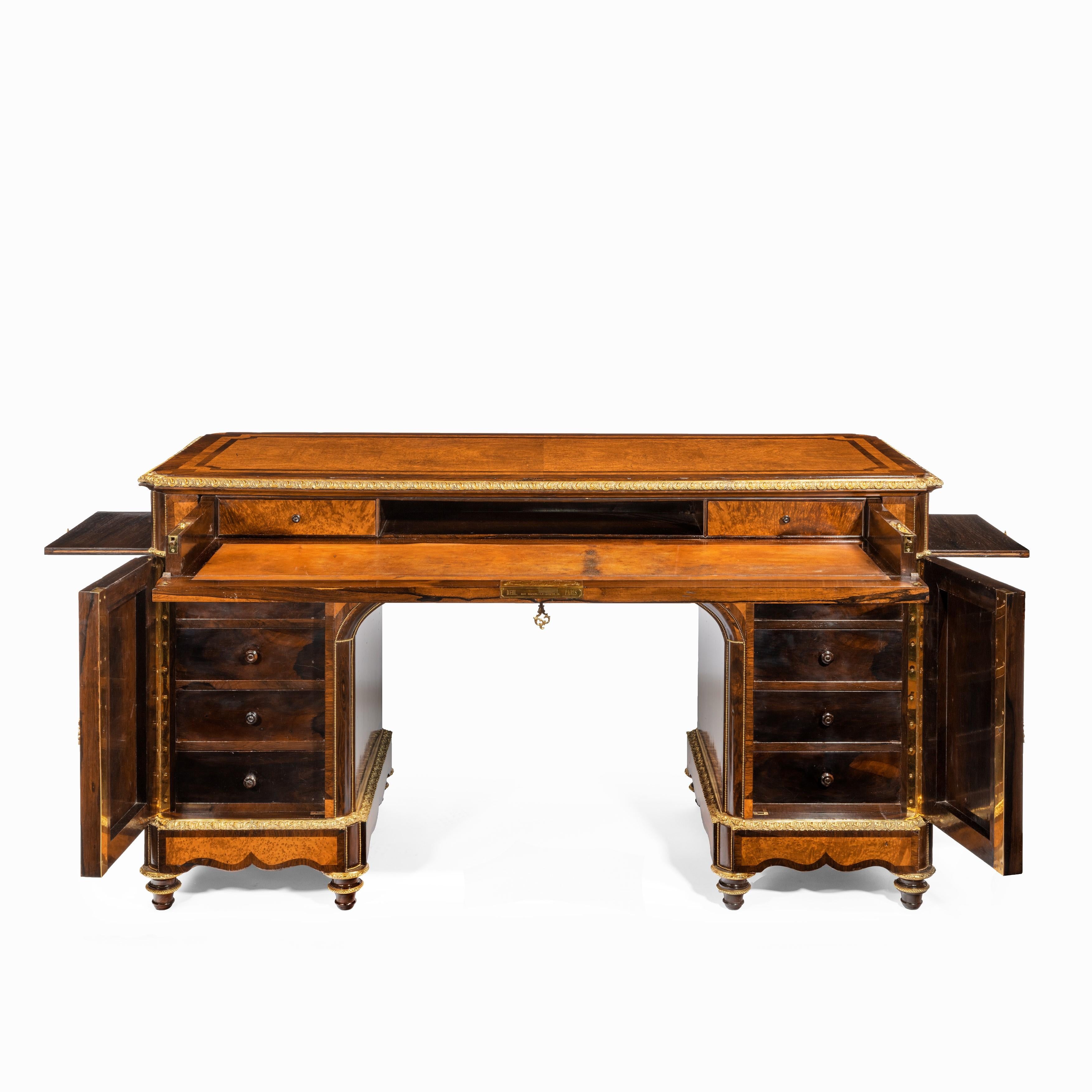 An unusual amboyna Napoleon III secretaire desk by Diehl, the rectangular top above a single long frieze drawer which opens to reveal a leather-inset secretaire with a pigeonhole flanked by two small drawers, all above two pedestals, each enclosing