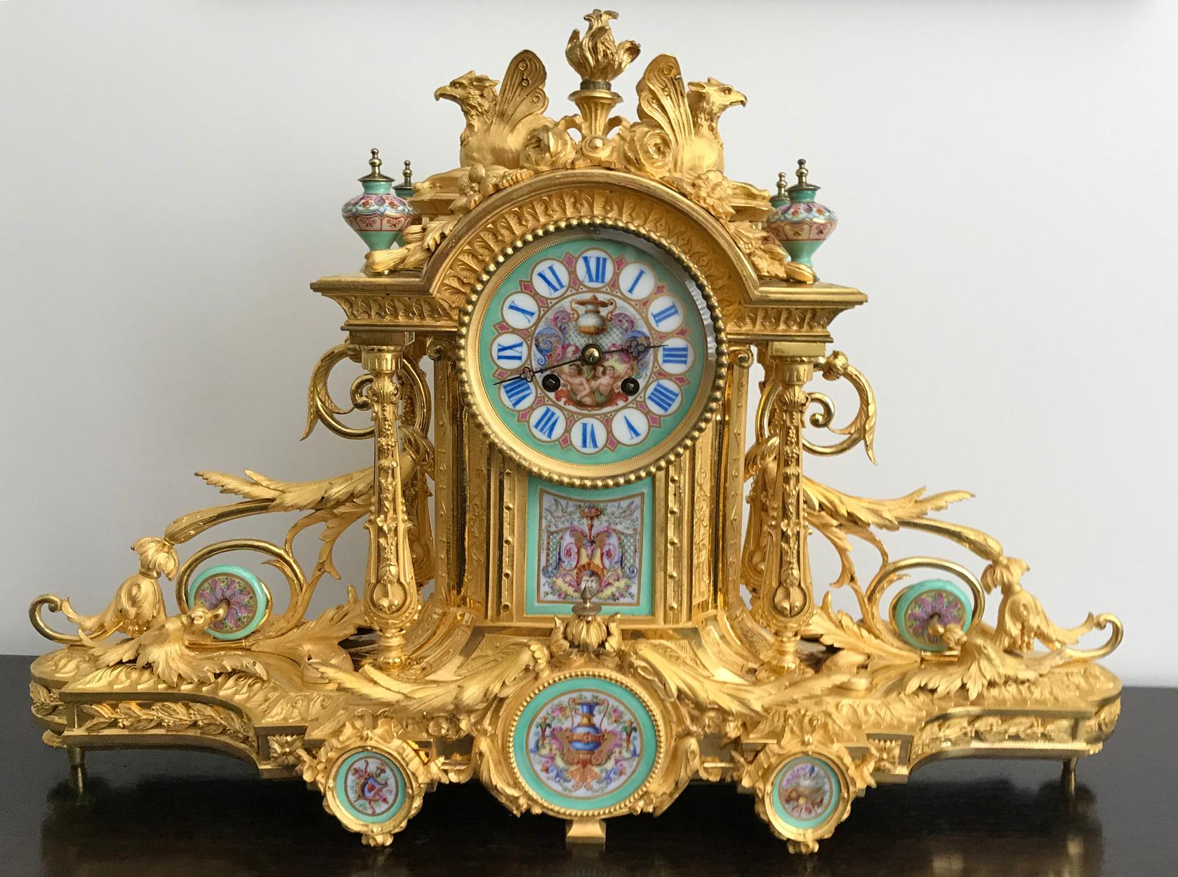 A magnificent Napoleon III Sèvres Porcelain mounted gilt bronze mantel clock, circa 1870 by Howell James & Co, clockmakers to Queen Victoria. 

The profusely decorated case surmounted by a flaming torchère and two winged Griffin, with a painted