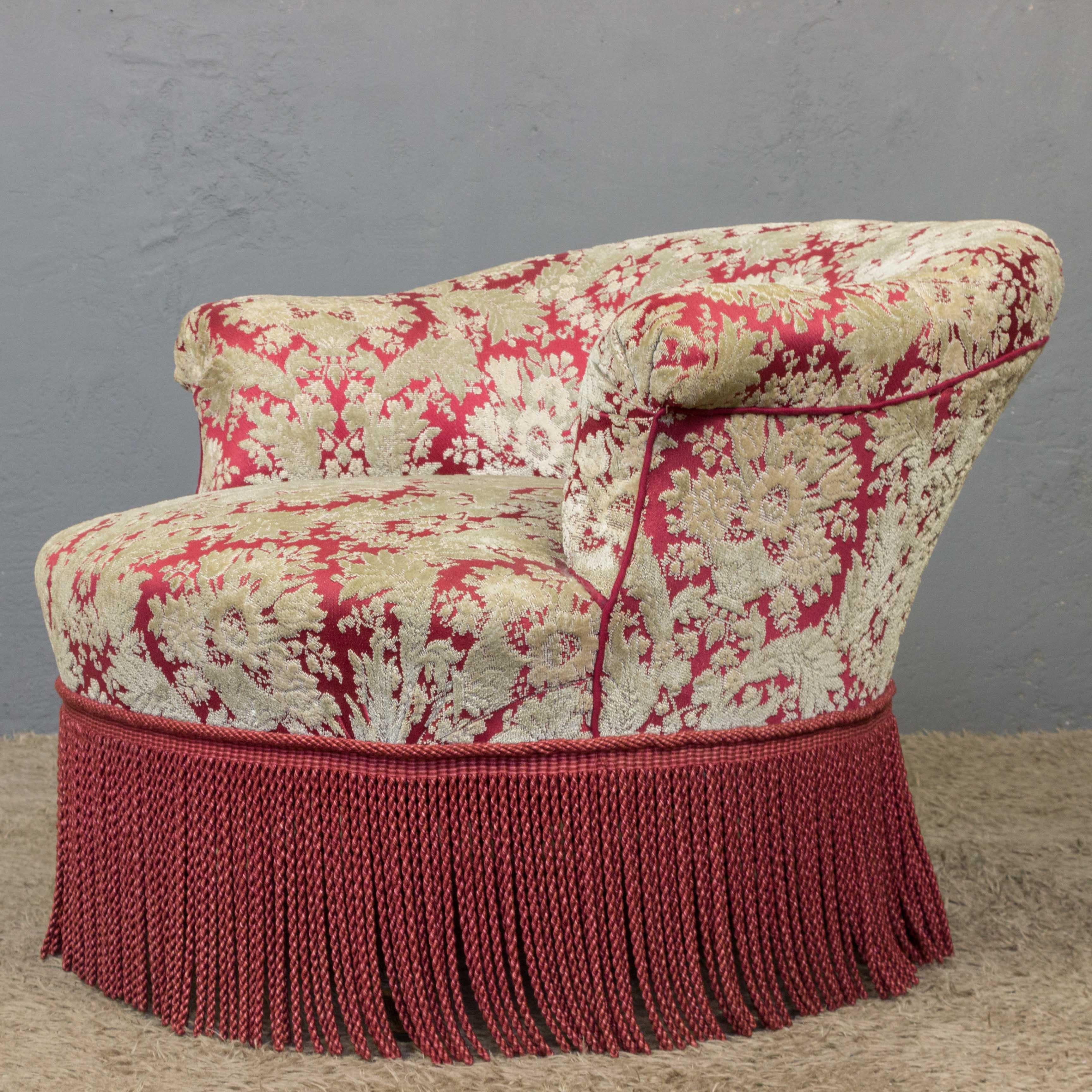 A stunning French Napoleon III slipper chair. This slipper chair is a truly unique piece, with its vintage floral fabric and bullion fringe providing an eye-catching contrast. In good vintage condition, this chair is sure to be a statement piece in