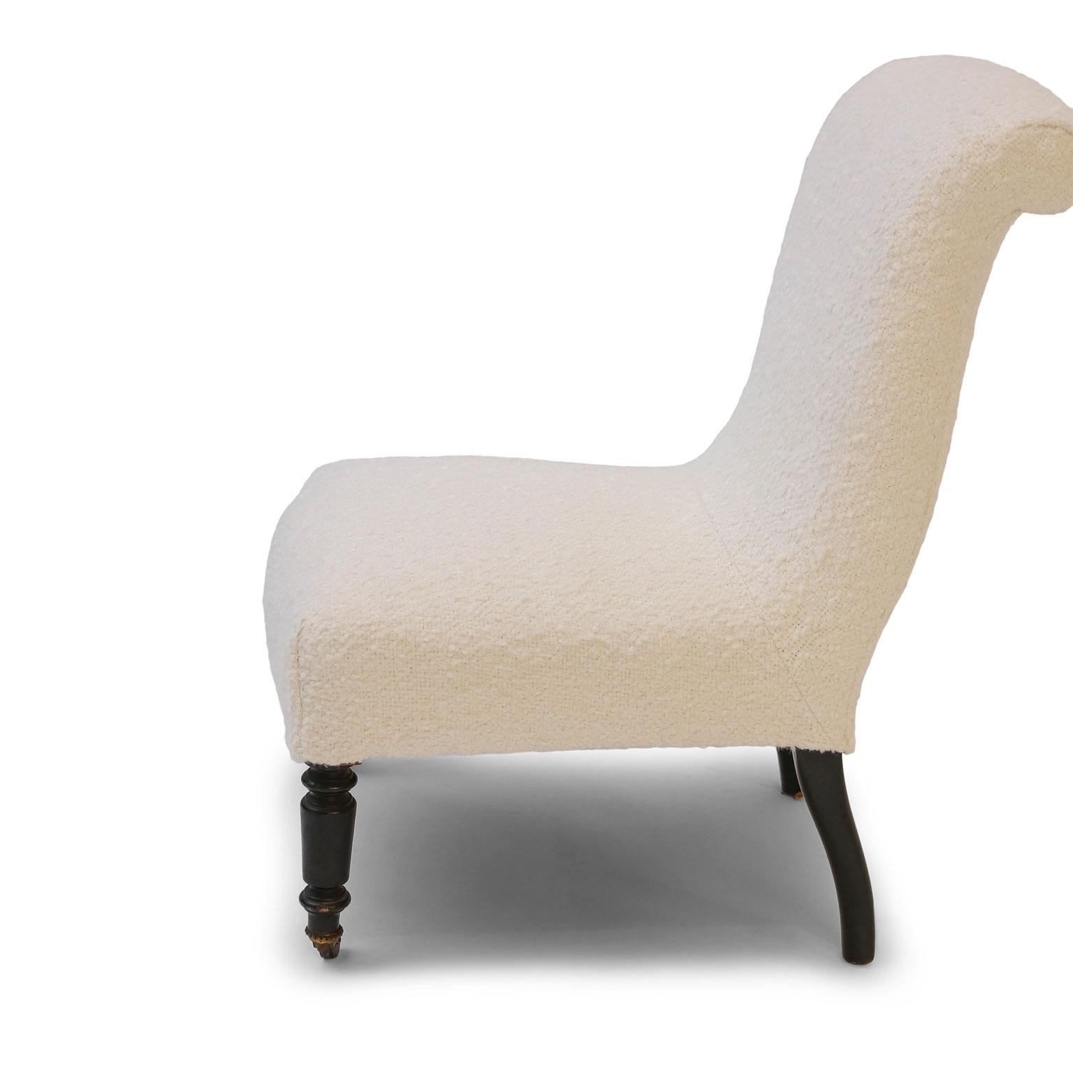 Napoleon III slipper chair newly covered in off-white Belgian wool bouclé. Upholstery and joints reworked. Front legs raised upon casters.