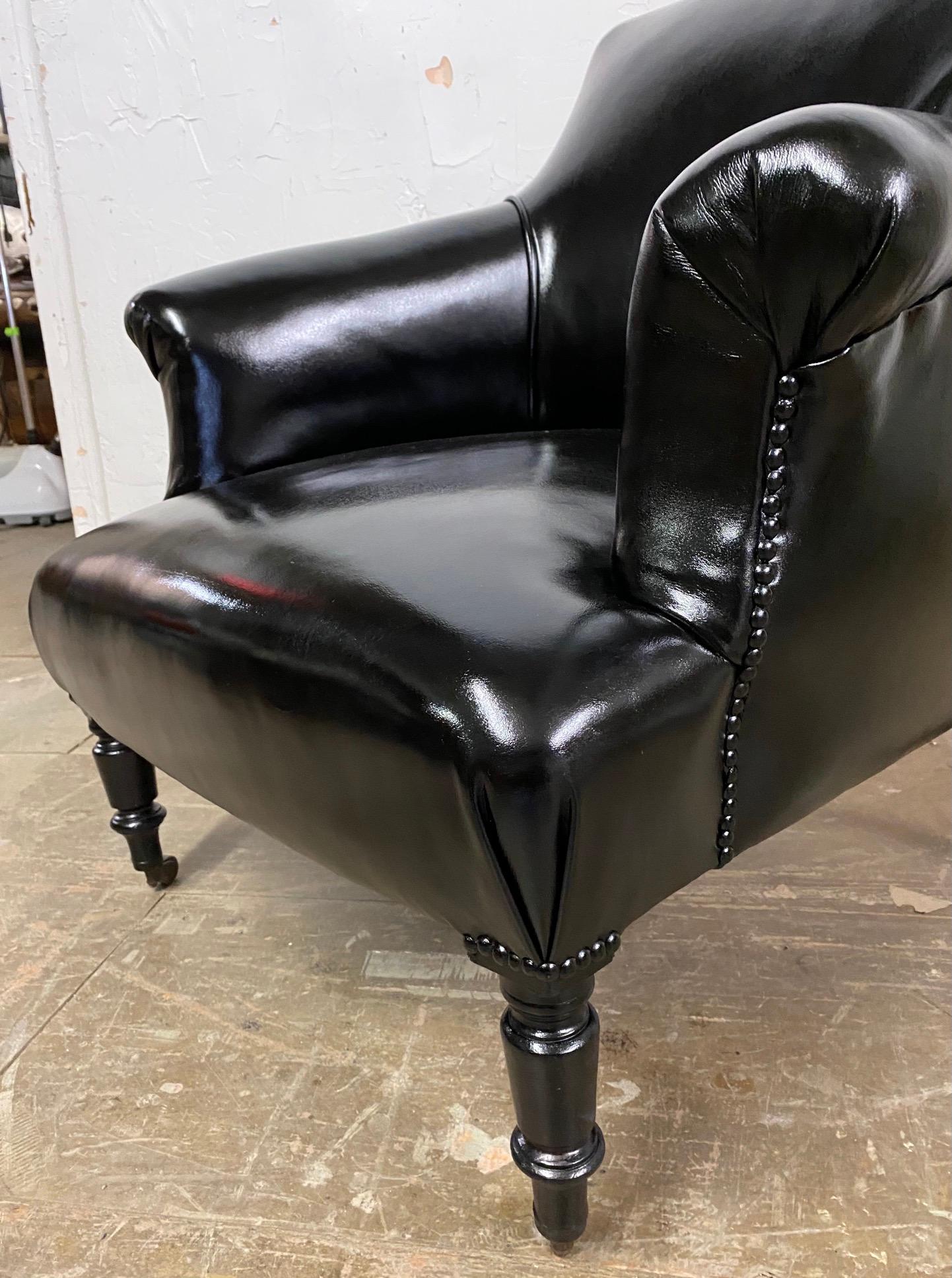 Un élégant fauteuil club ou de salon Napoléon III en cuir noir. La chaise a des pieds typiques du style Napoléon III et est recouverte de cuir avec une finition à clous.