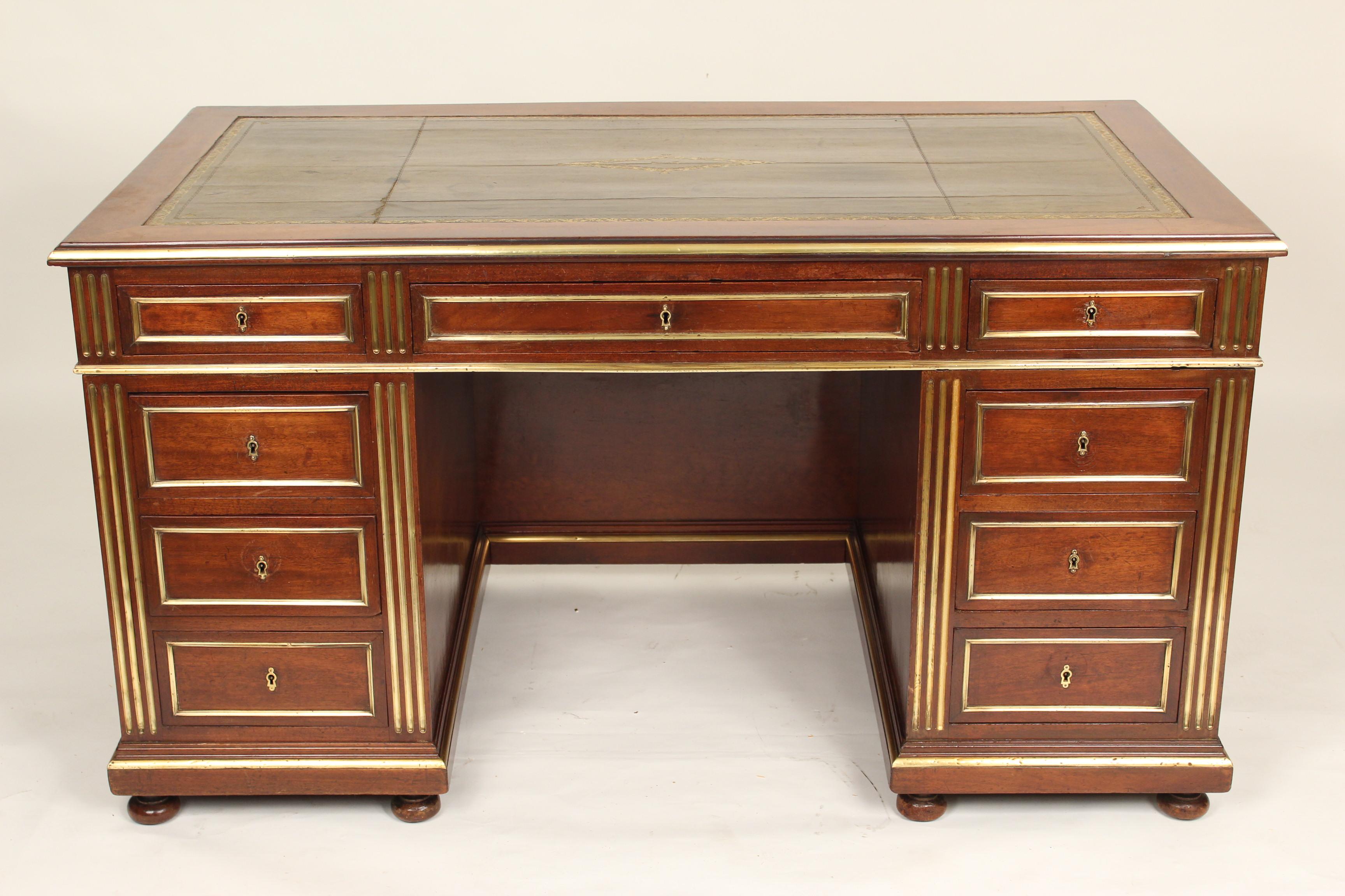 Napoleon III style mahogany double pedestal desk with brass inlay, brass moldings, tooled leather top, modesty board and pull out writing slides on each end, circa 1880.