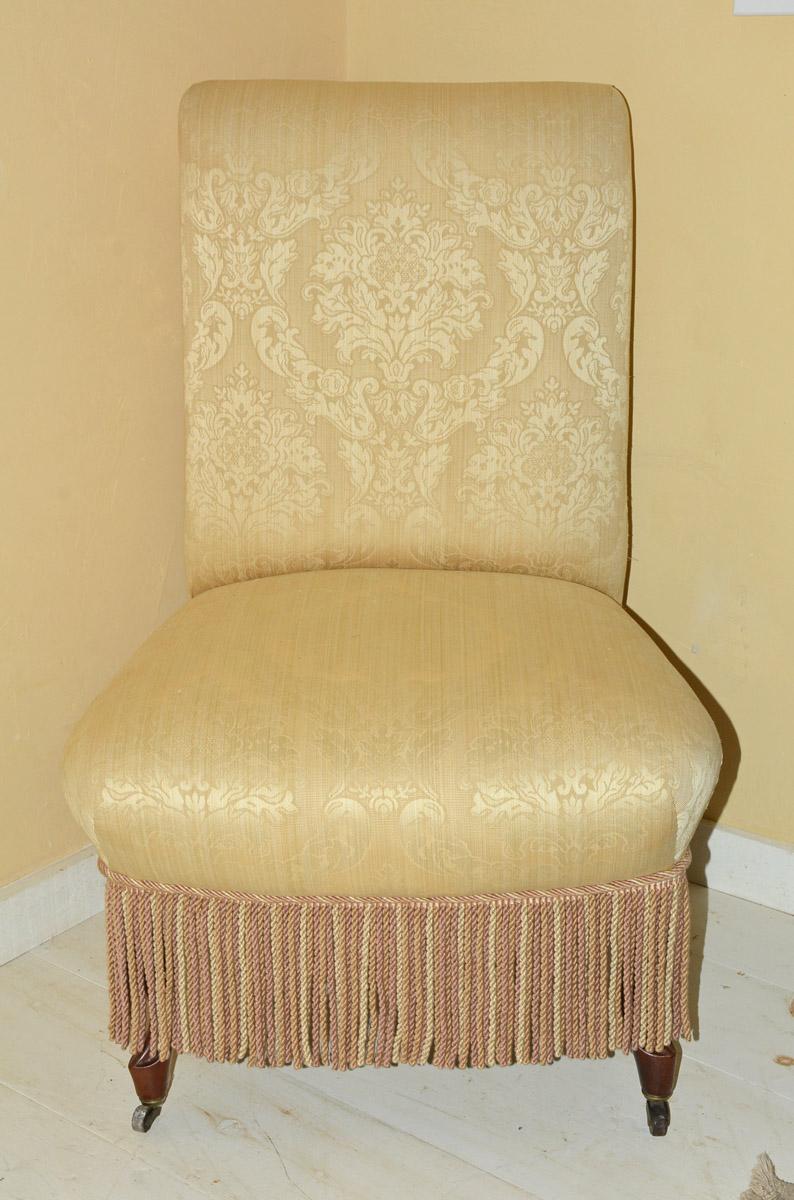 The slipper chair reflects the Napoleon III style of the mid-19th century with gold brocade fabric with deep cushion affect and exuberant fringe. Front legs end in casters.

Measures: Seat height - 19